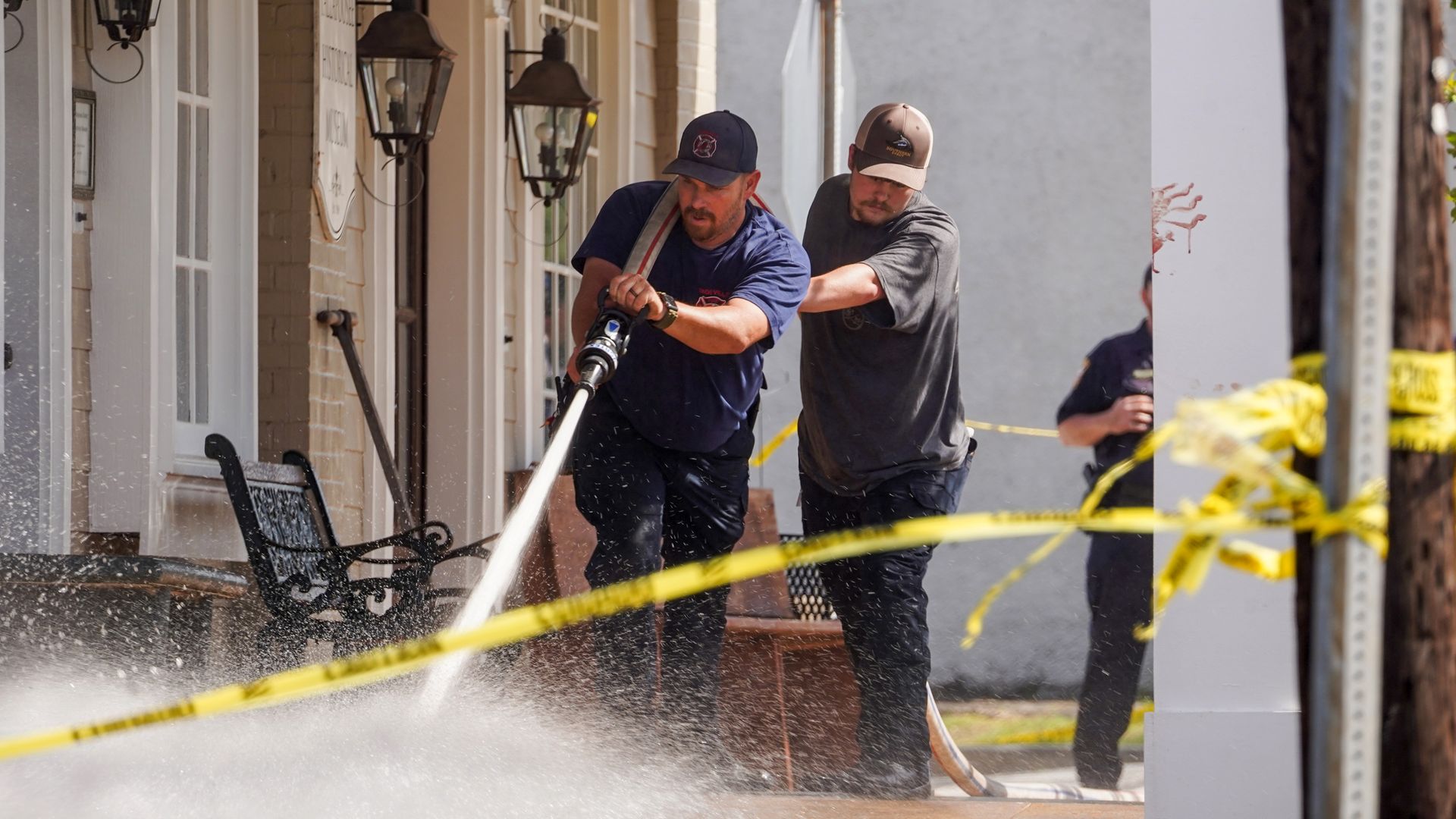 Fire fighters use a hose to wash down the scene of a mass shooting that left four people dead and 28 other wounded in Dadeville, Alabama, on April 16.