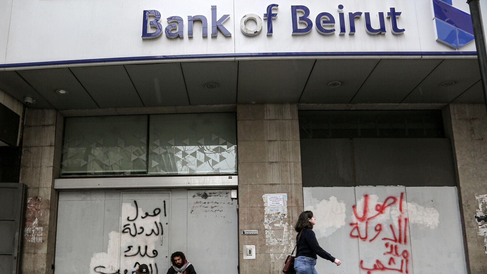  A Lebanese couple sits outside a closed fortified local bank branch in Beirut on March 14. Photo: Marwan Naamani/picture alliance via Getty Images