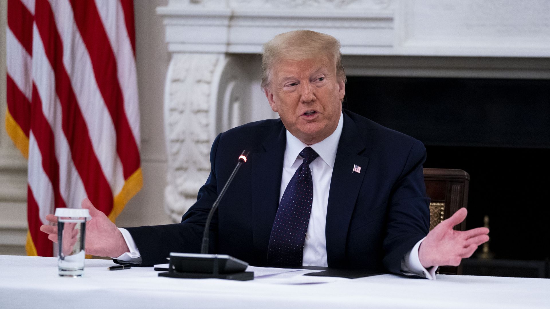 Trump sits in a suit in this picture