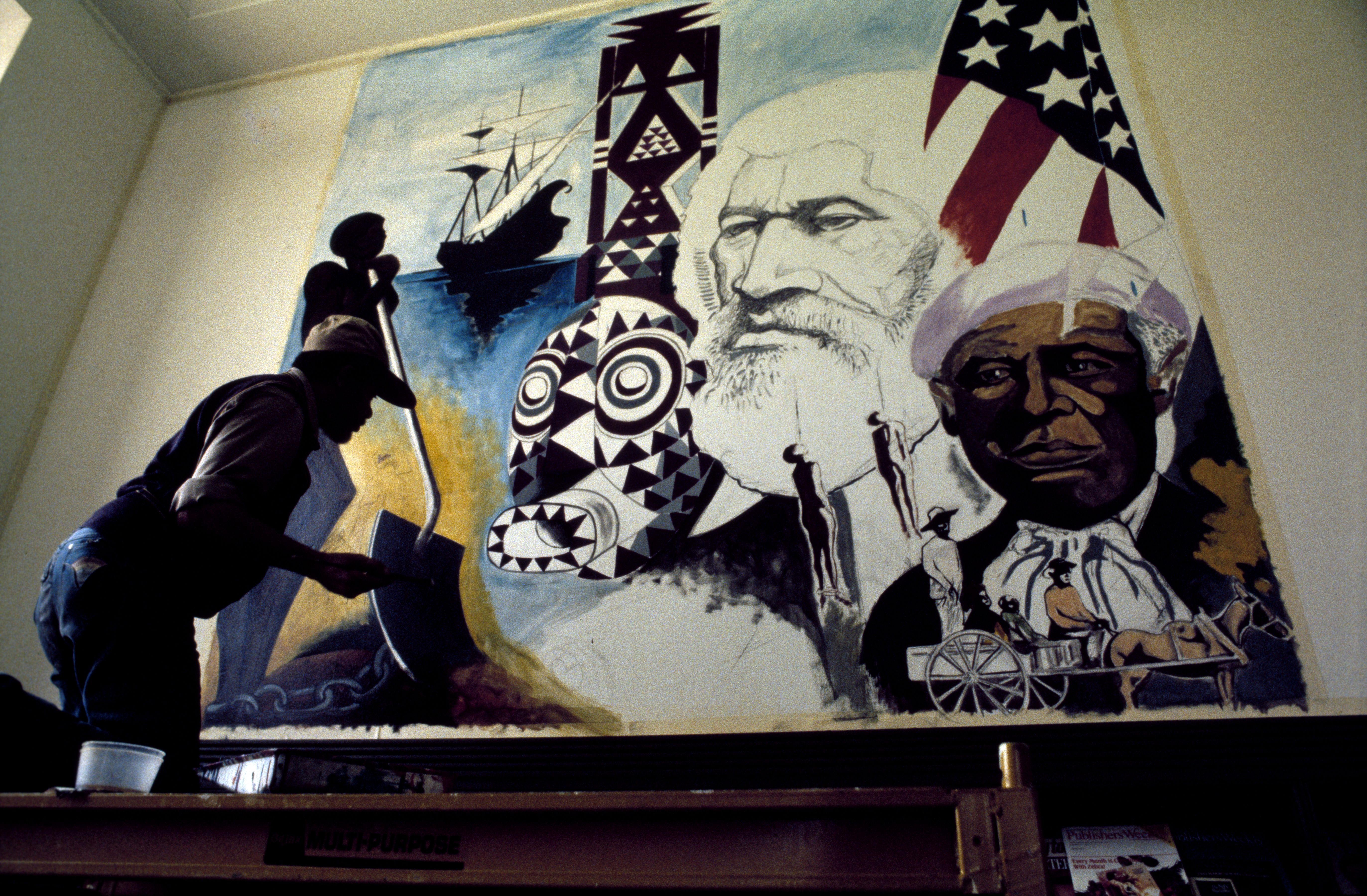 Photo of an artist painting a mural 