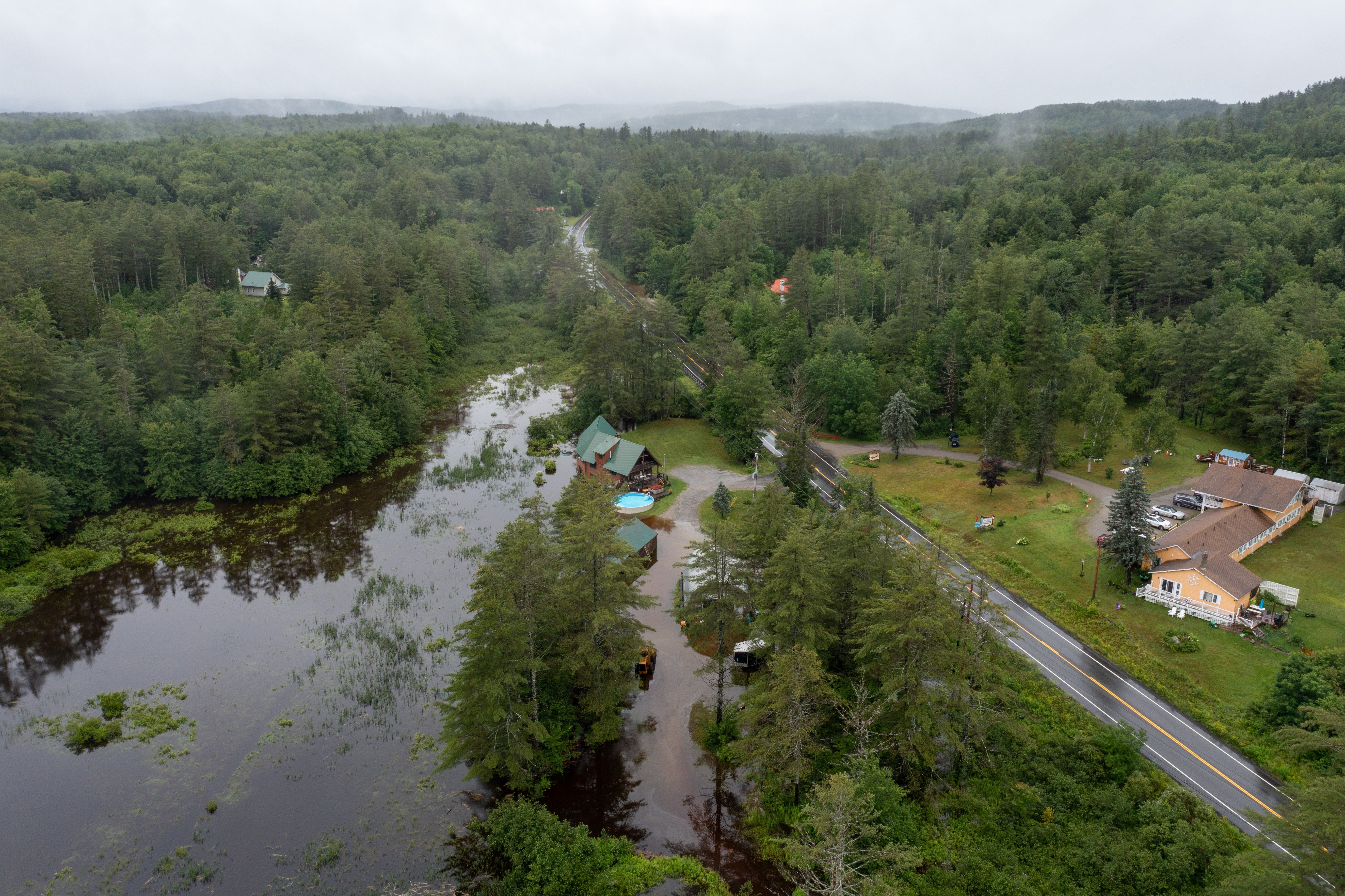 In an aerial view, water covers residential property on Route 11 after heavy rain on July 10, 2023 in Londonderry, Vermont. 