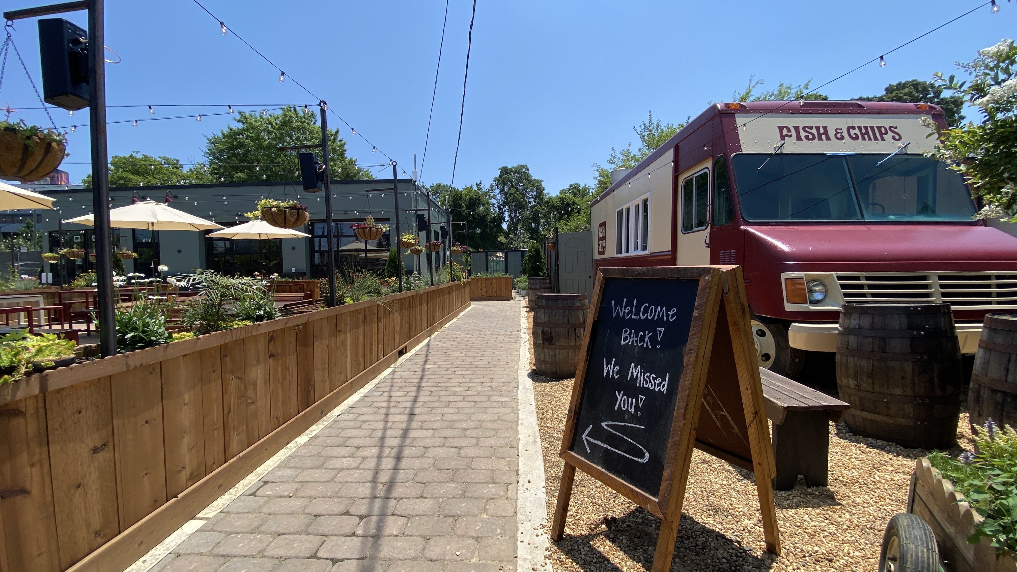A food truck to the right that says "fish & chips" and a patio to the left. 