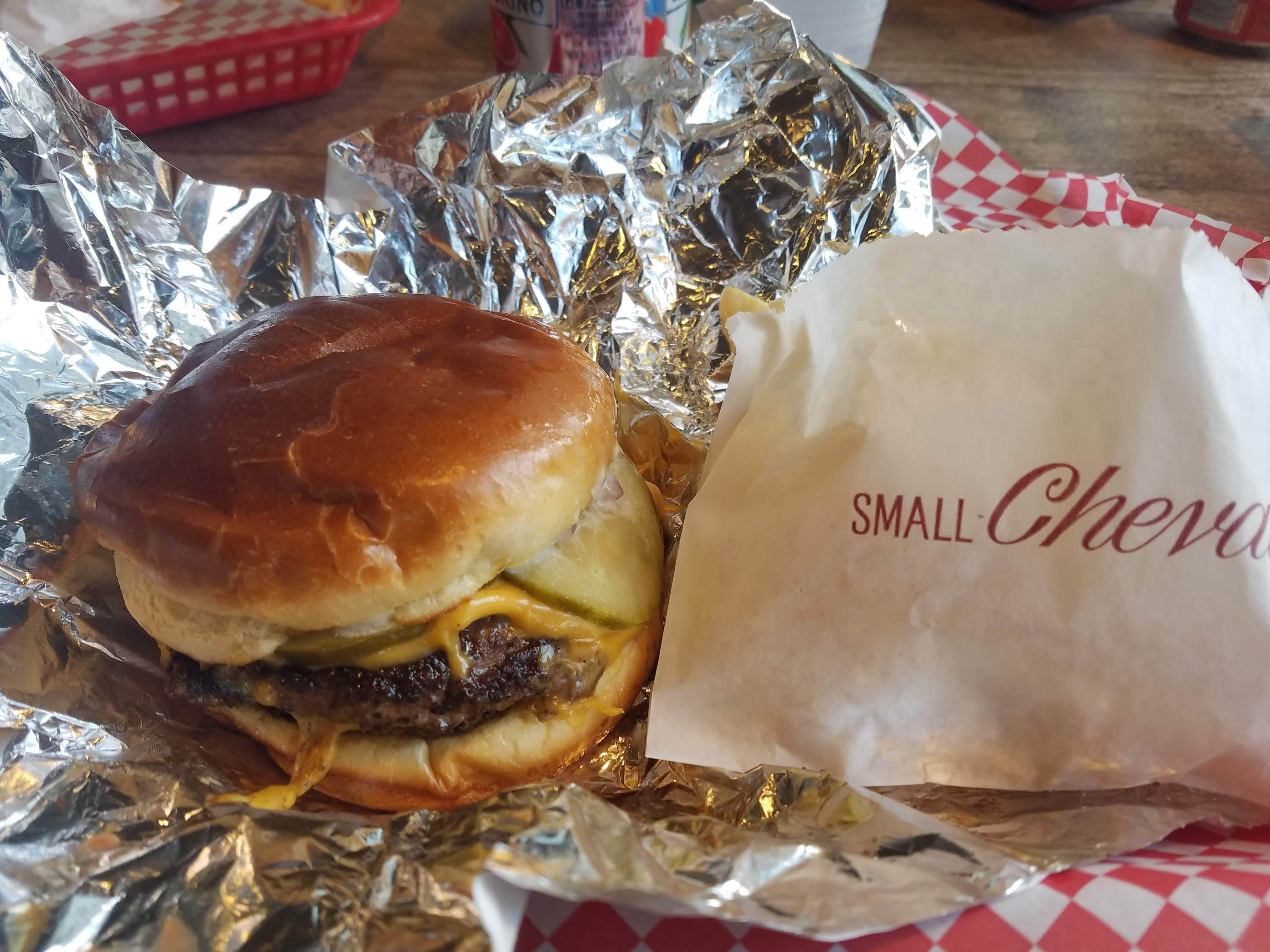Photo of a cheeseburger in a tin foil wrapping 