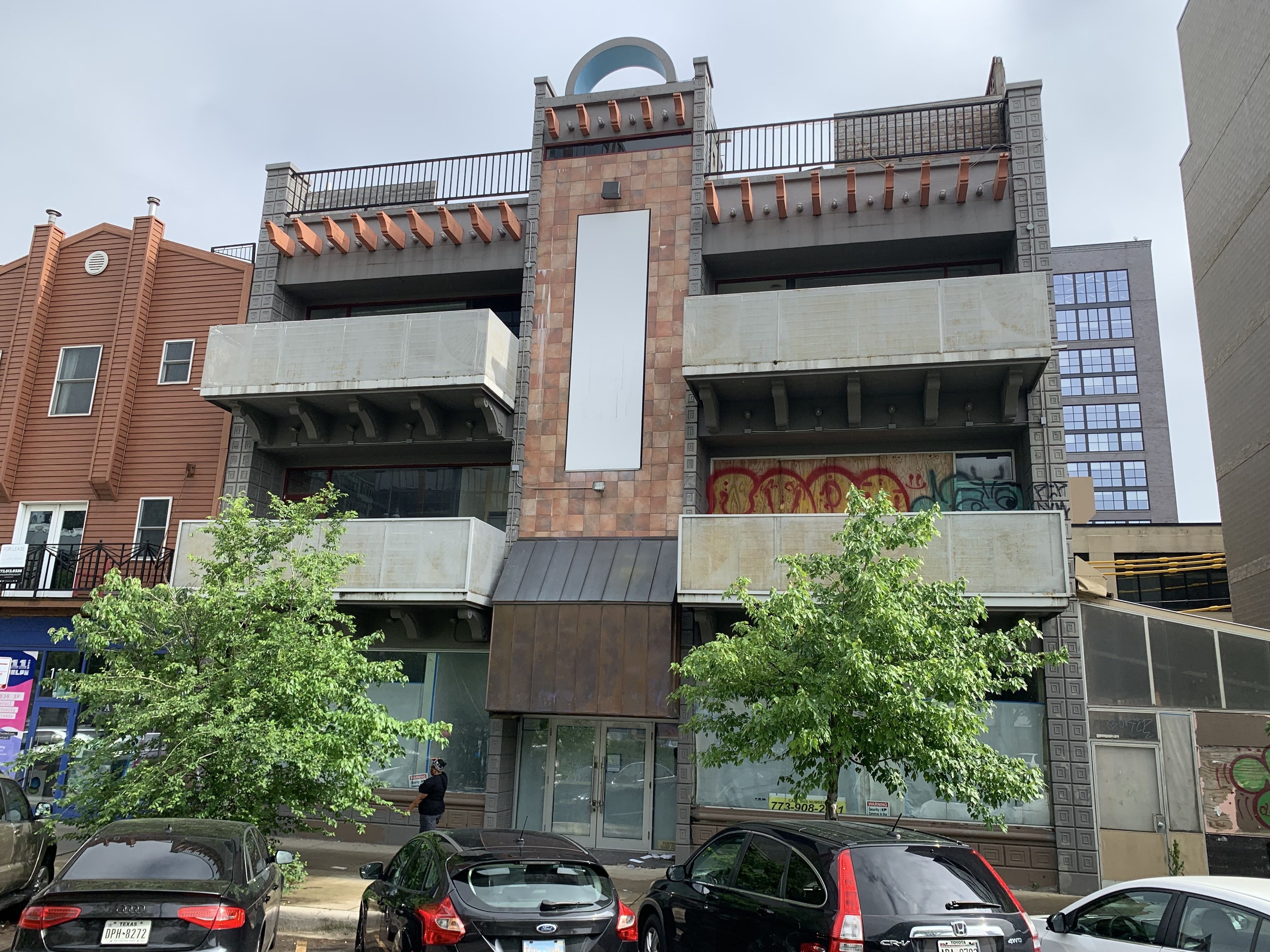 Building with two rows of three balconys that have graffiti on them.