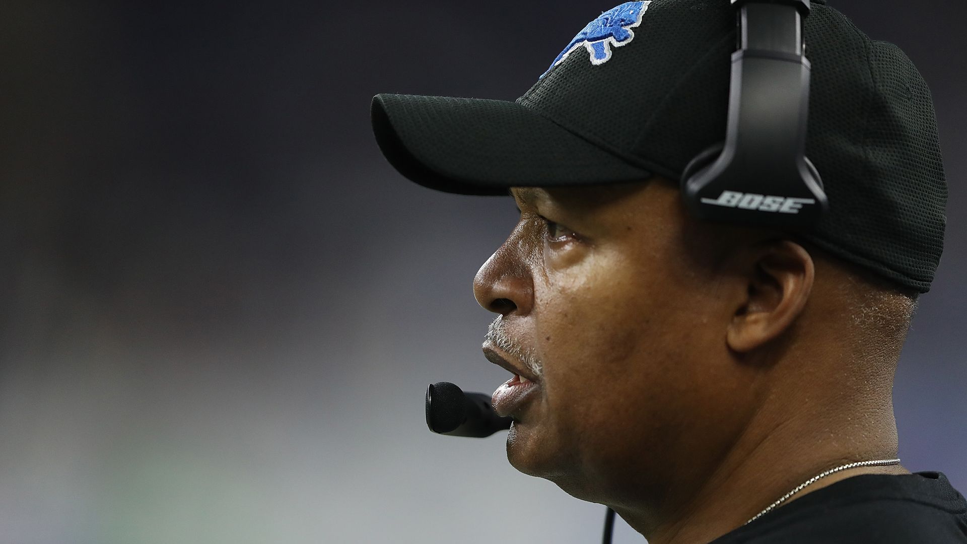 A photo of a football coach on the sidelines. 