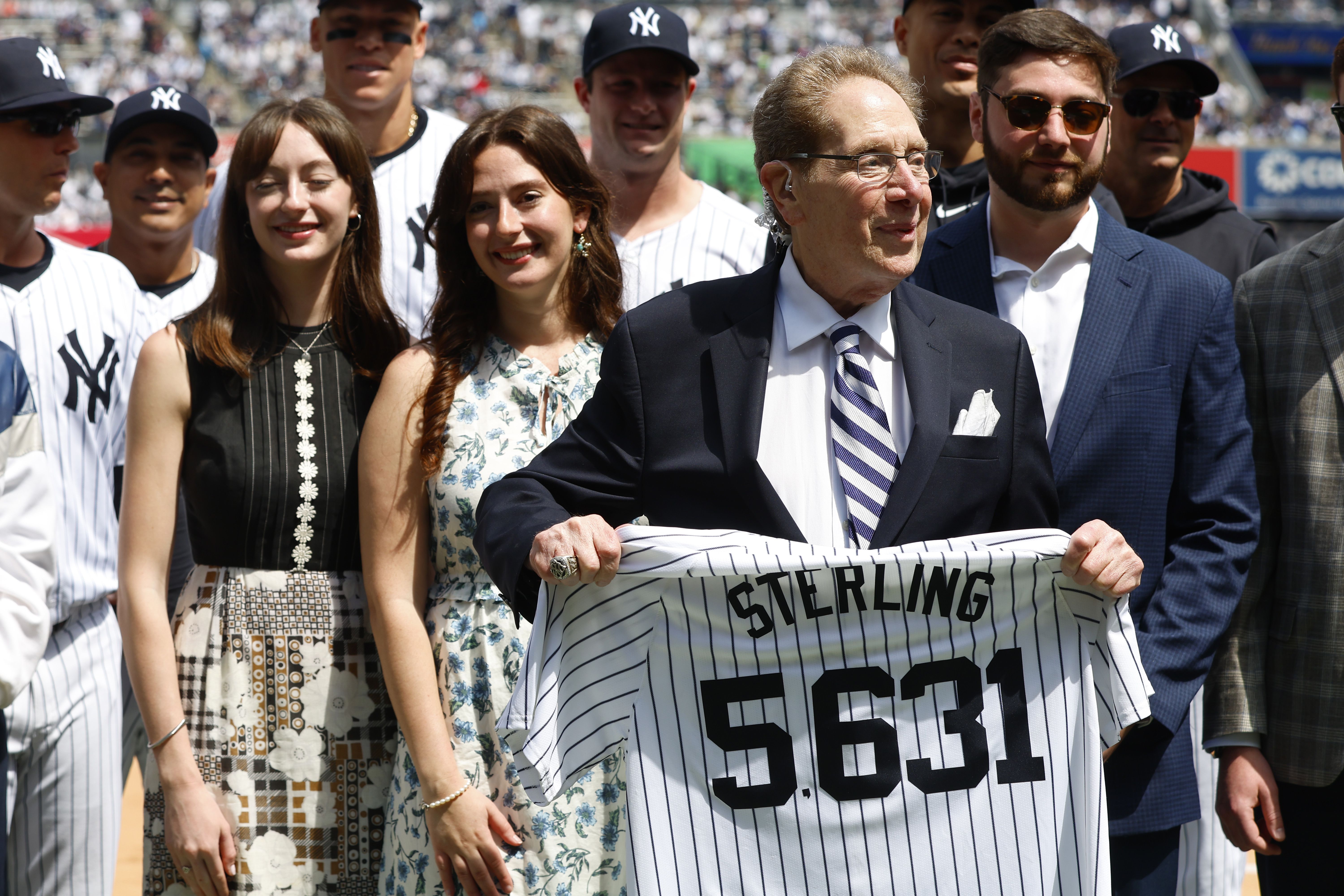 New York Yankees broadcaster John Sterling holds a jersey that has the number of games he broadcasted during a retirement ceremony before a baseball game agains the Tampa Bay Rays at Yankee Stadium 