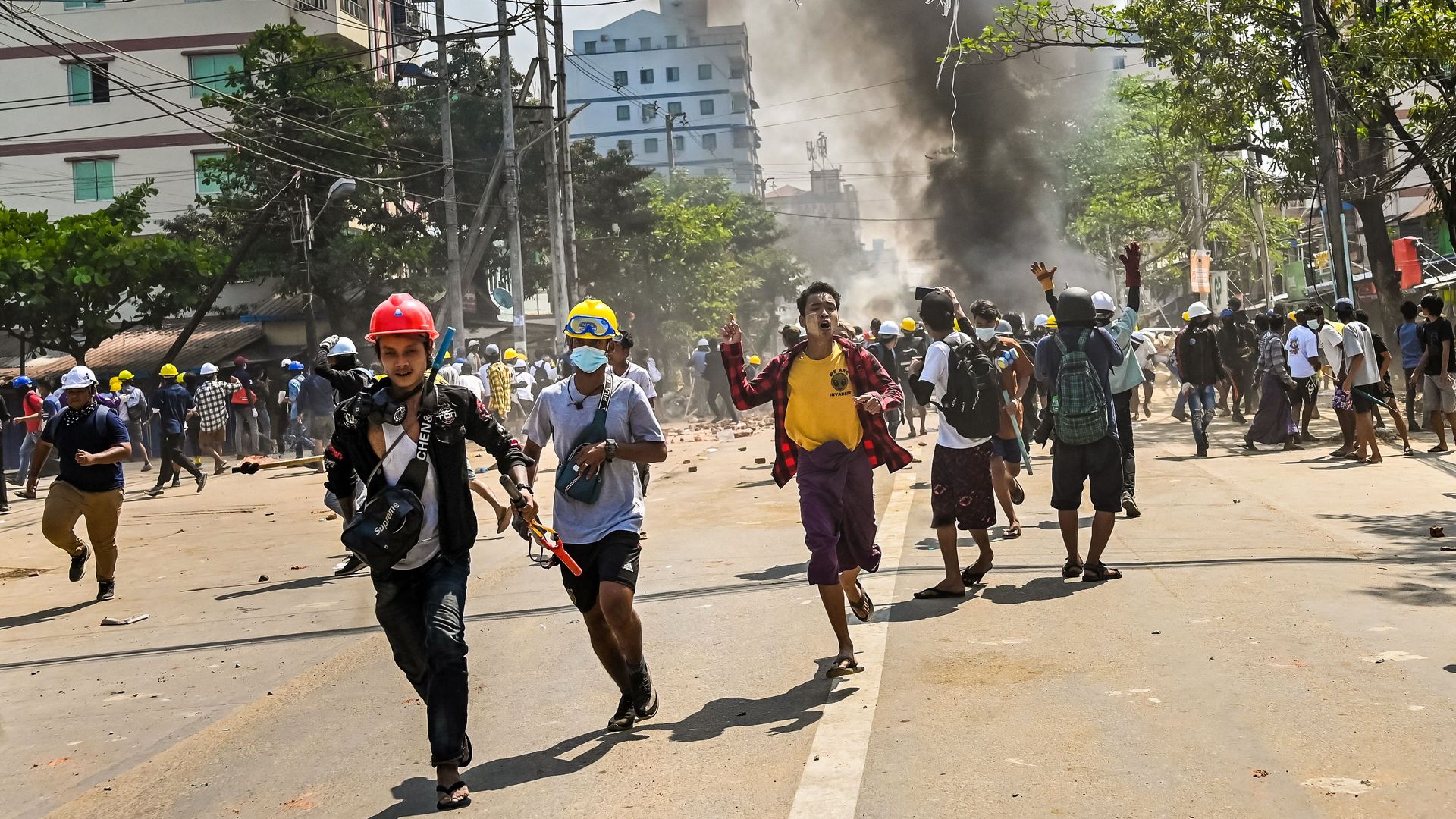 Protesters running from tear gas during a demonstration against the military coup in Yangon's Thaketa township on March 19.