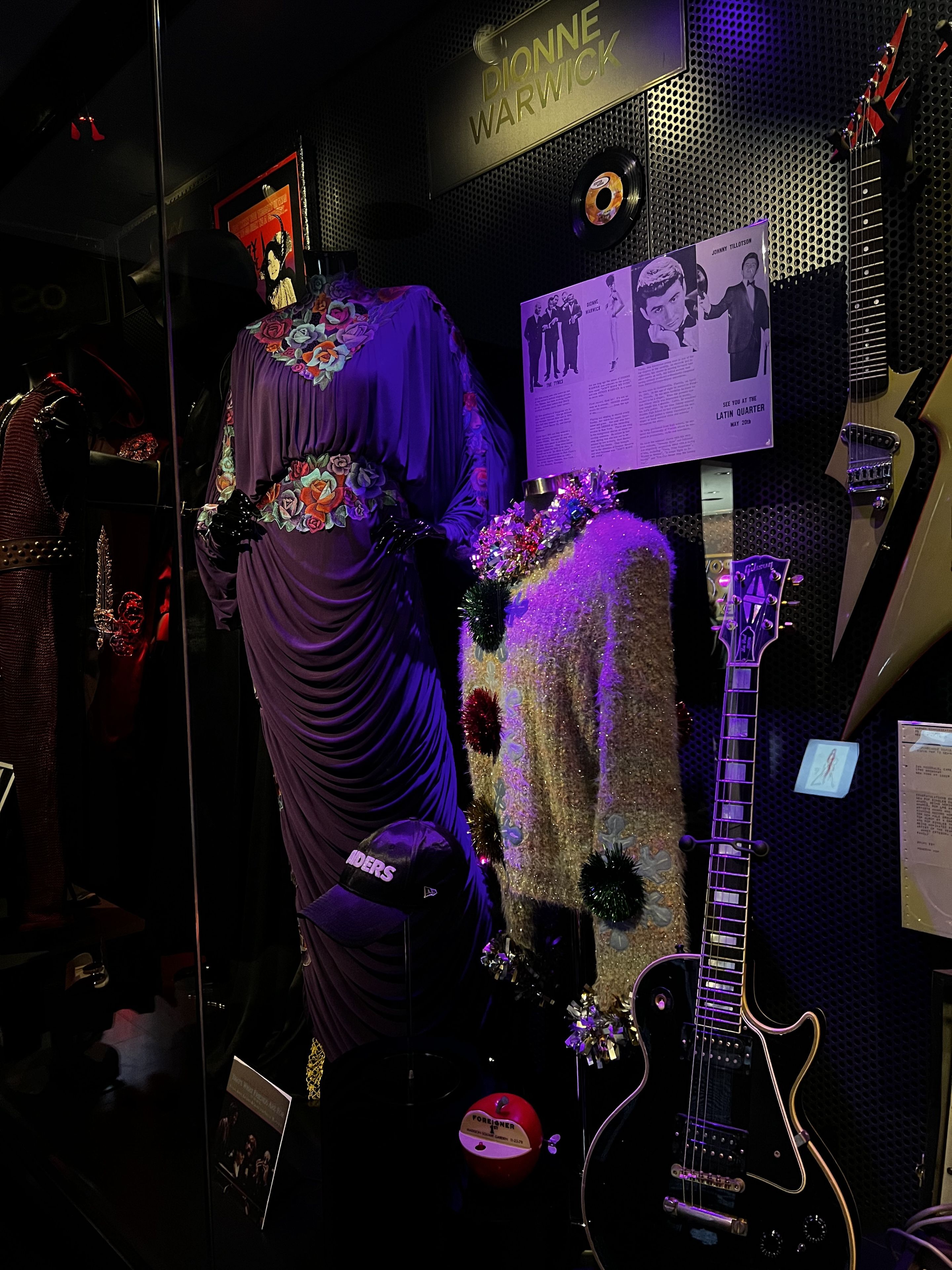 Dionee Warwick dresses behind a glass case.