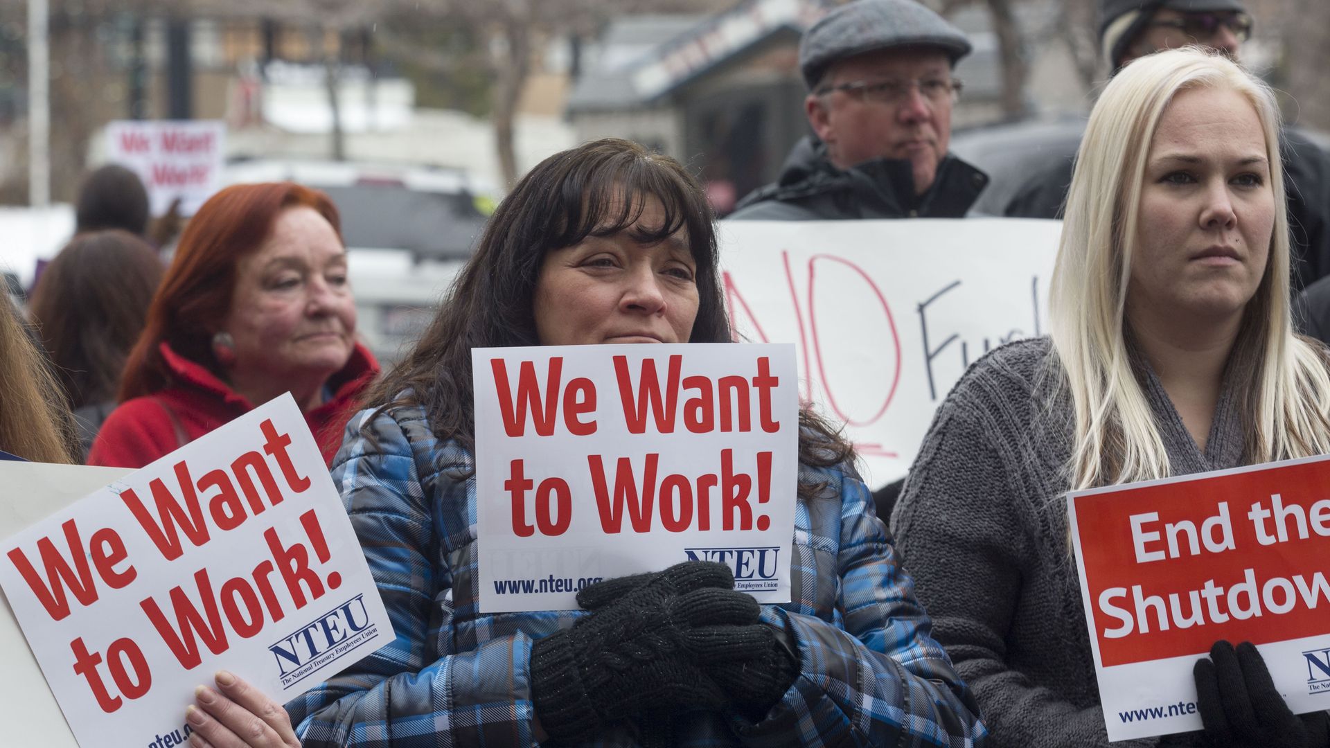IRS employee Donna Orton (C) holds a sign protesting the government shutdown at the James V. Hansen Federal Building in Ogden, Utah.