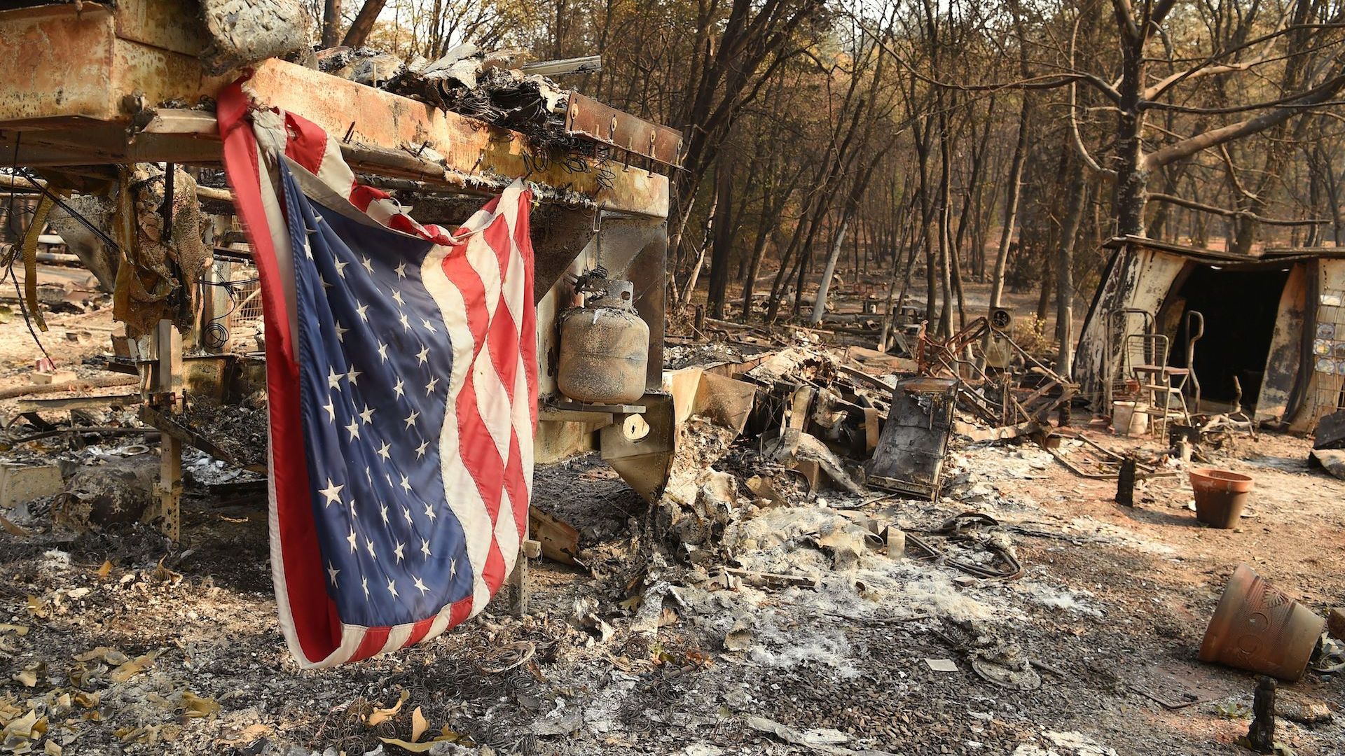 An American flag hangs at a burned out mobile home park in Paradise, California