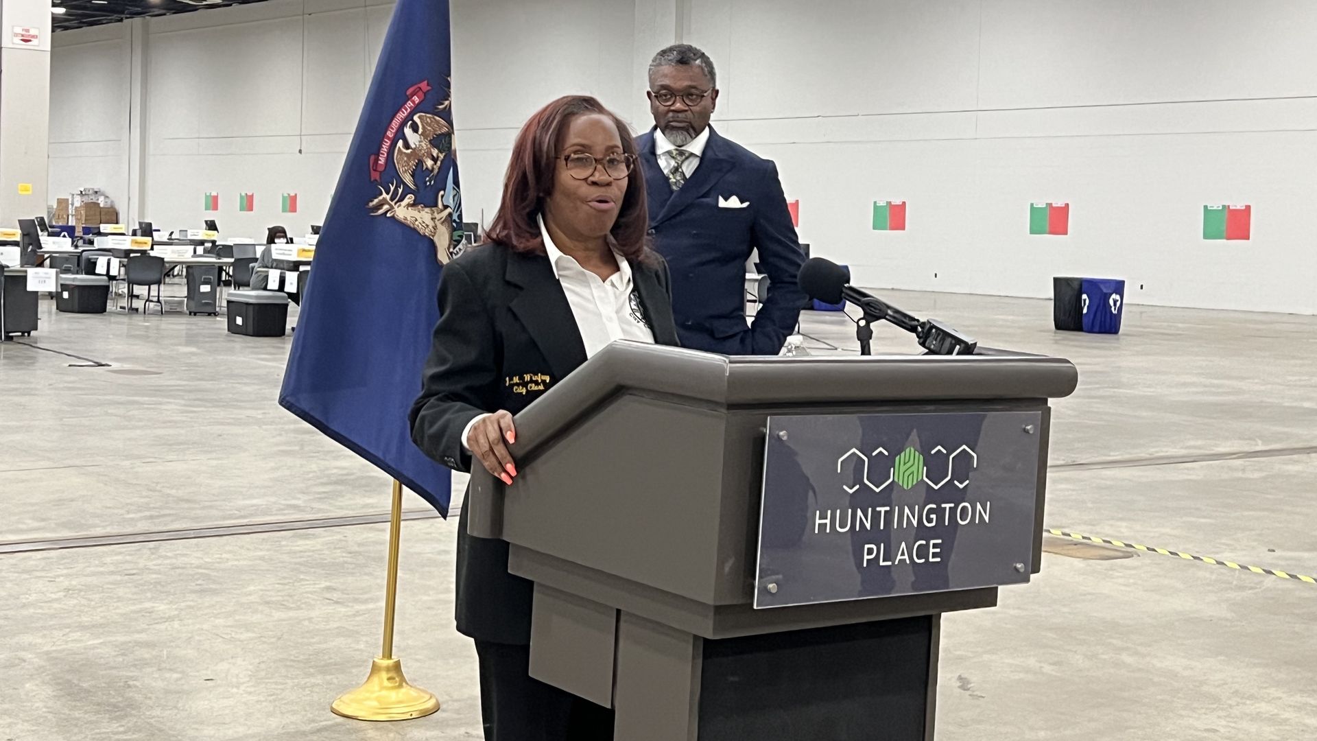 Detroit Clerk Janice Winfrey stand behind a podium in front of advisor Daniel Baxter