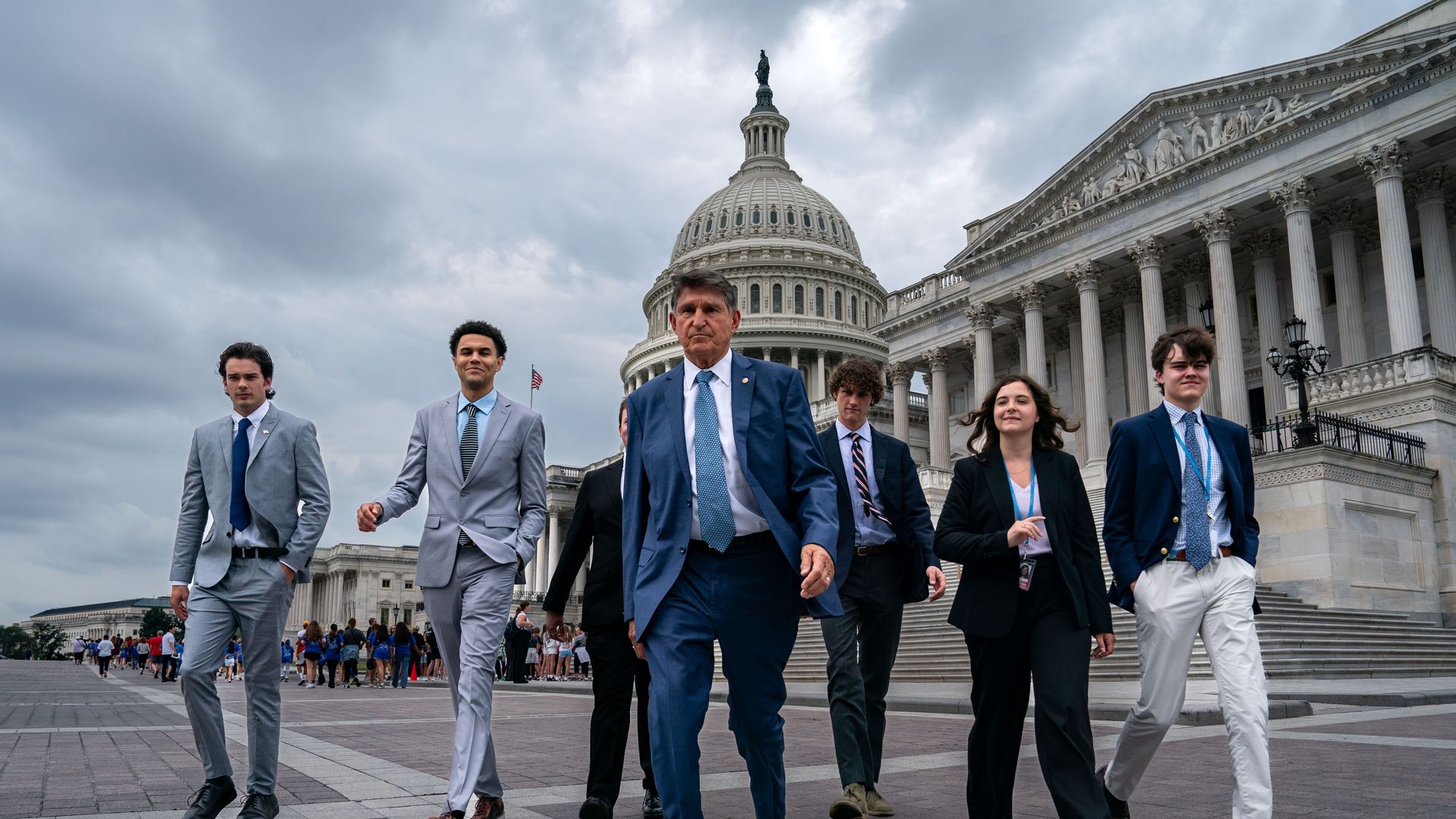 Joe Manchin walks in front of the Capitol with staffers