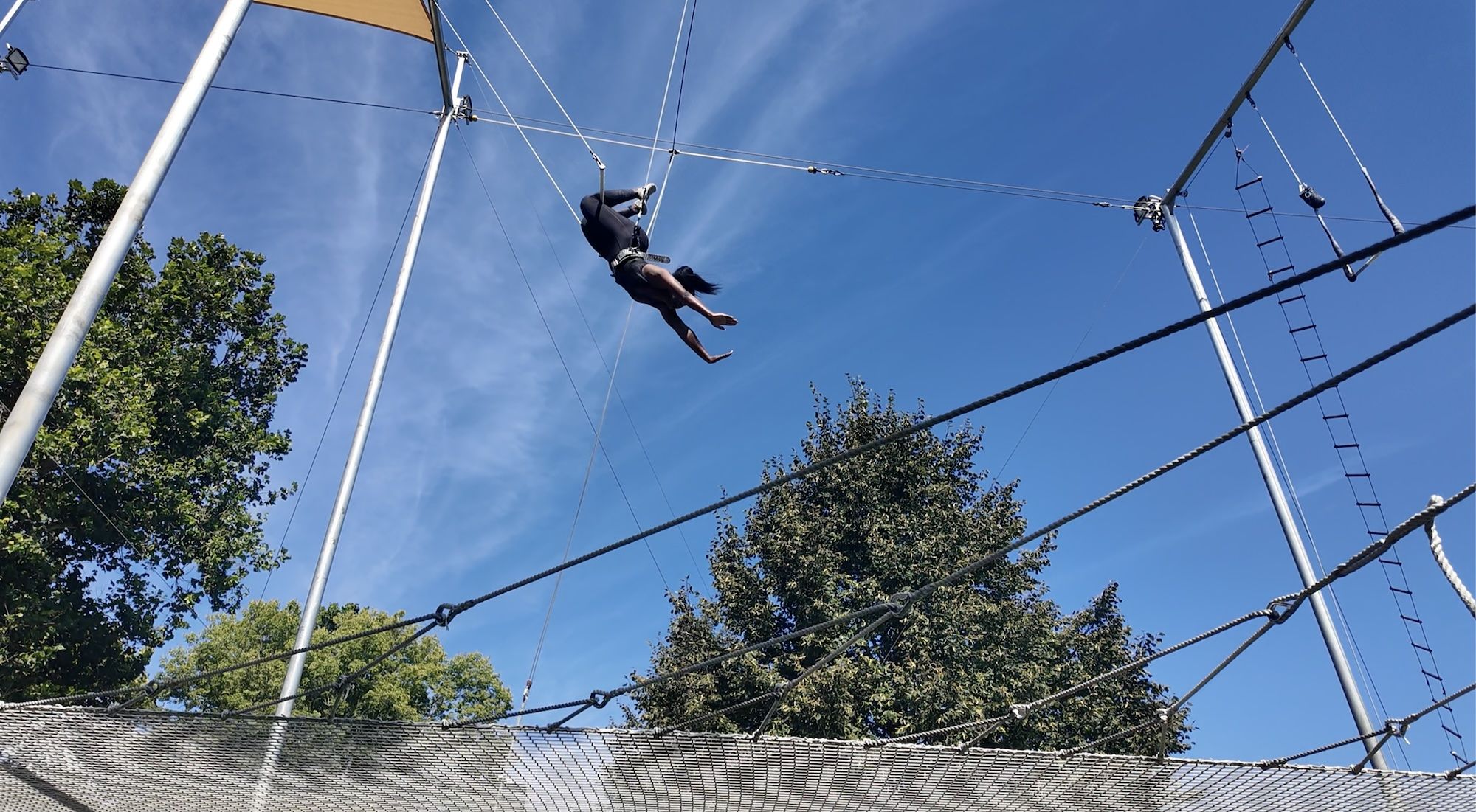 Woman flying in the air on trapeze.
