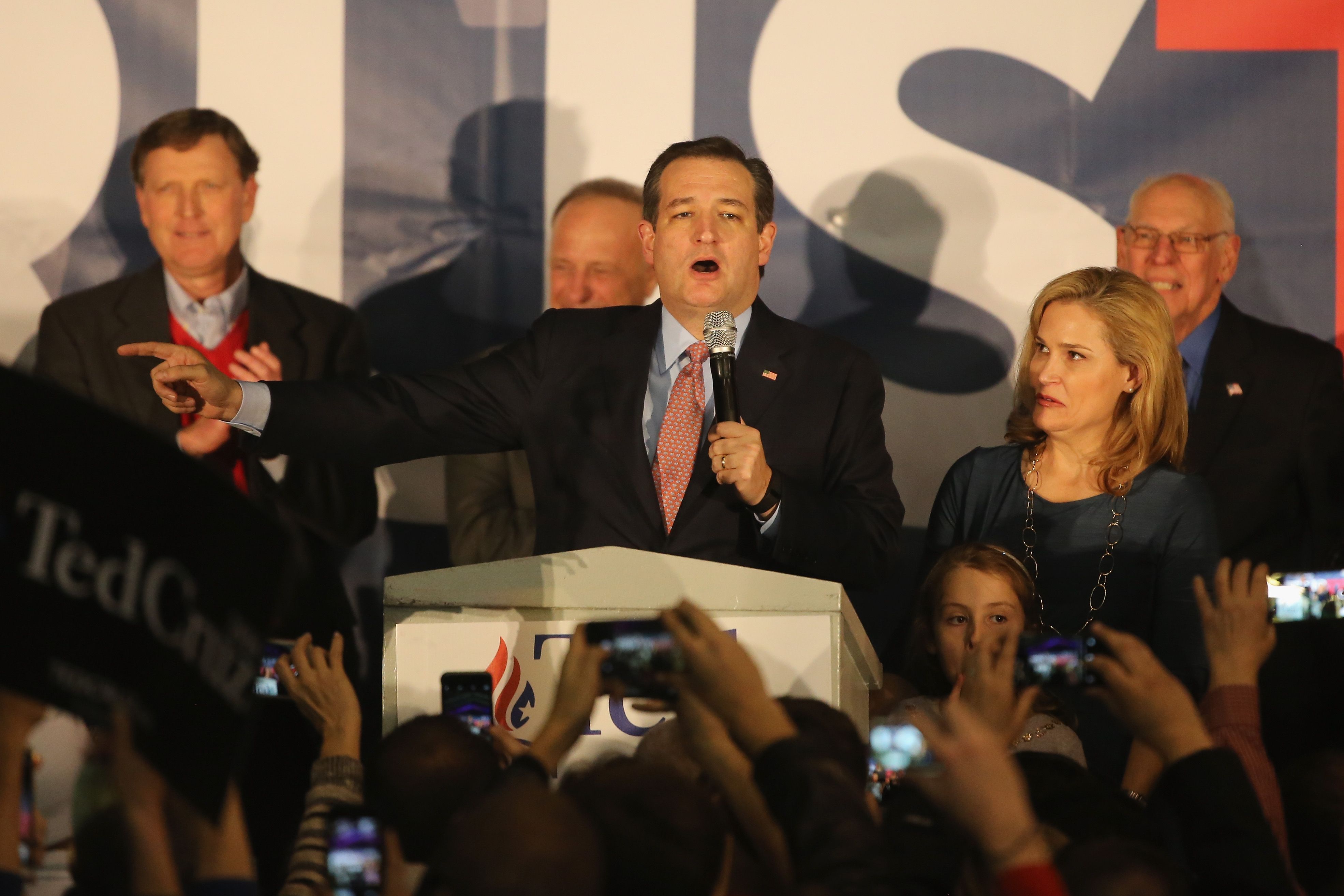 Ted Cruz holds a microphone and points while giving a speech