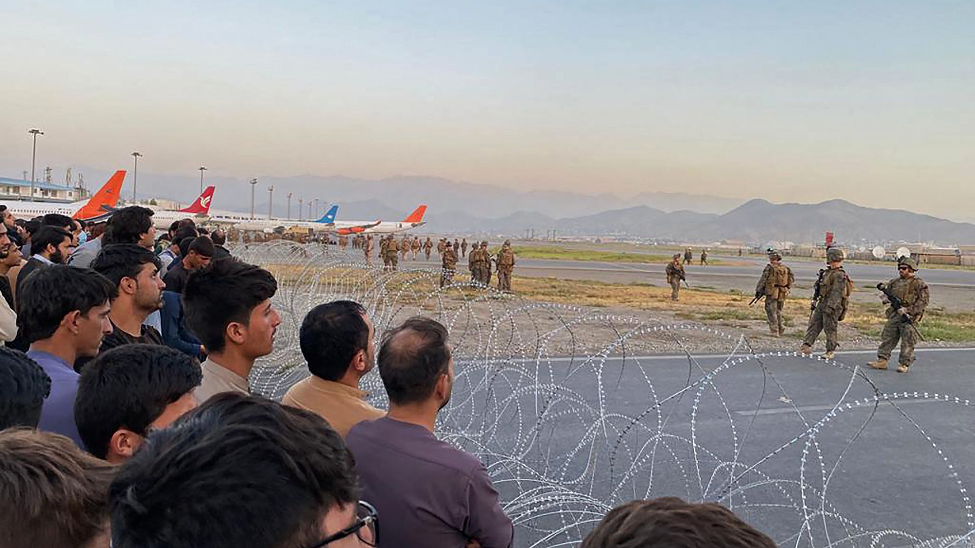 Afghans crowd at the airport as US soldiers stand guard in Kabul on August 16, 2021.