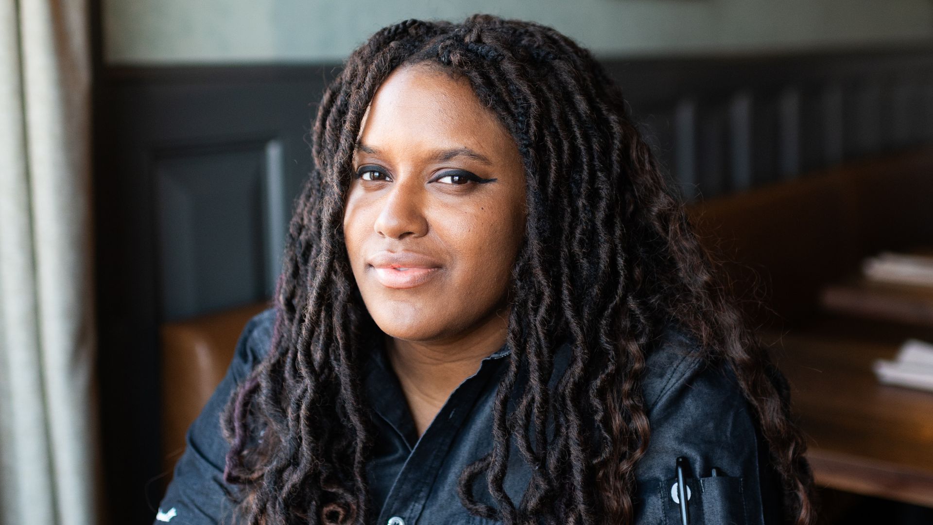 A Black woman chef looking smart and sexy in a restaurant  