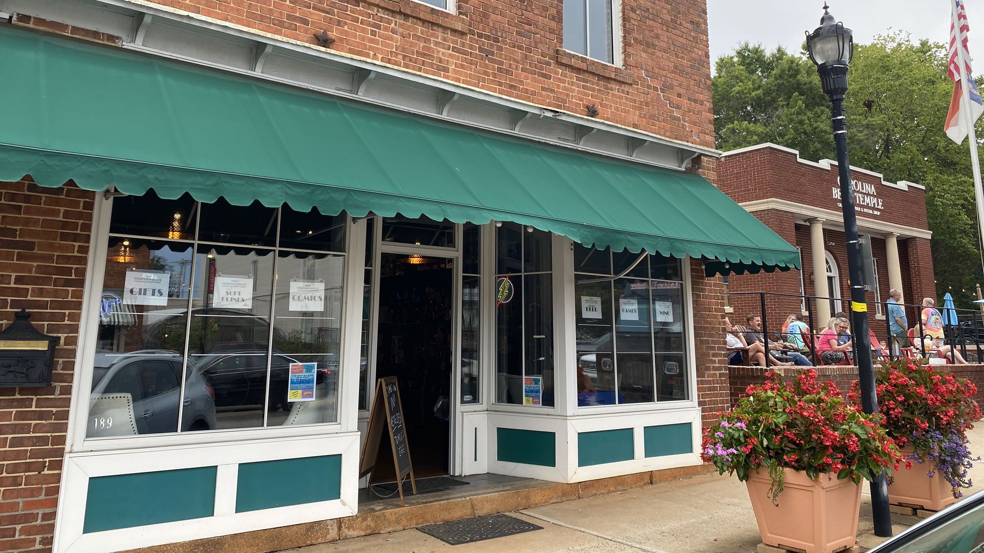 two-story brick building with a store front with green awning.