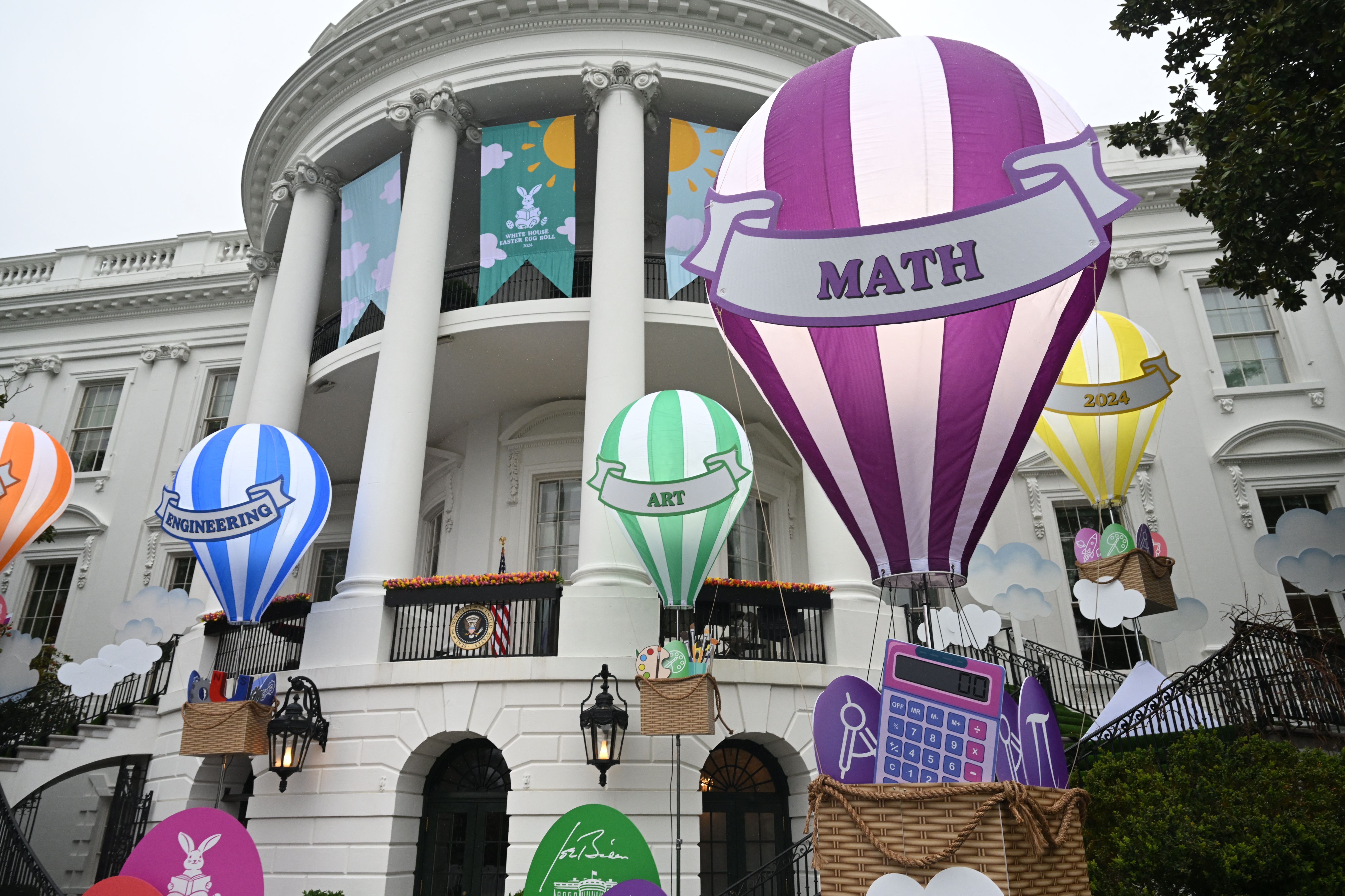 The White House in the background with education-related decorations in the foreground designed like hot air balloons.