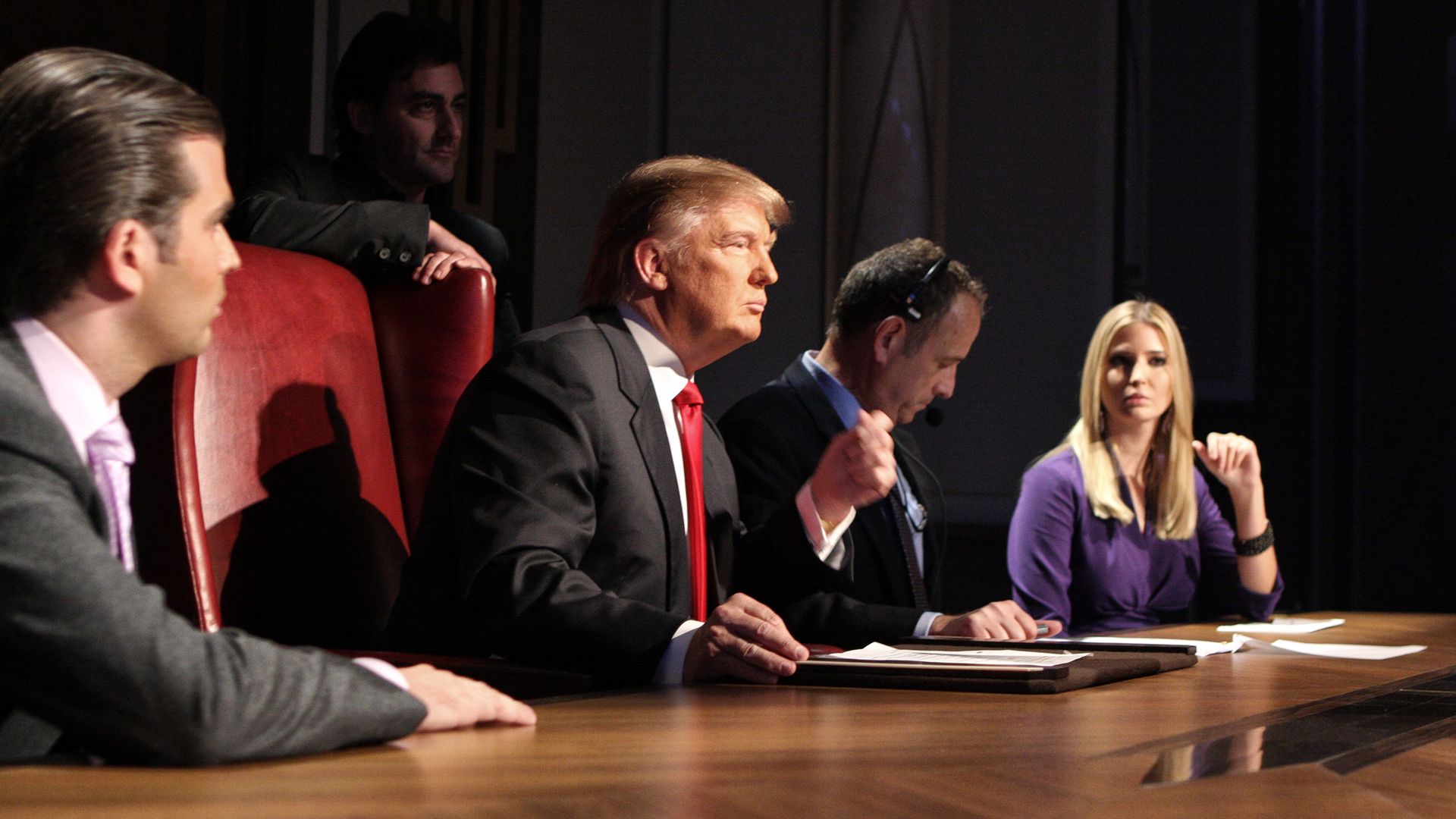 Donald Trump, Donald Trump Jr and Ivanka Trump sit at a desk during the Celebrity Apprentice. 