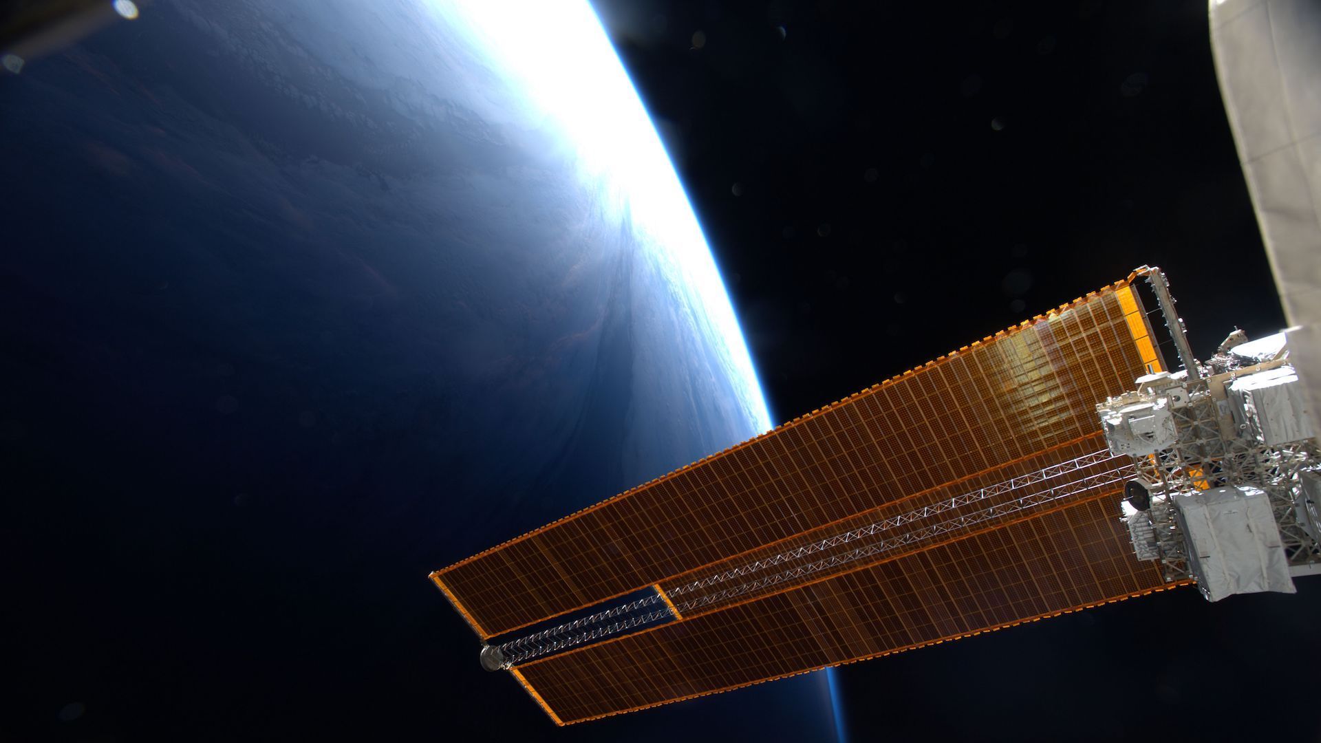 A solar panel of the International Space Station above the Earth
