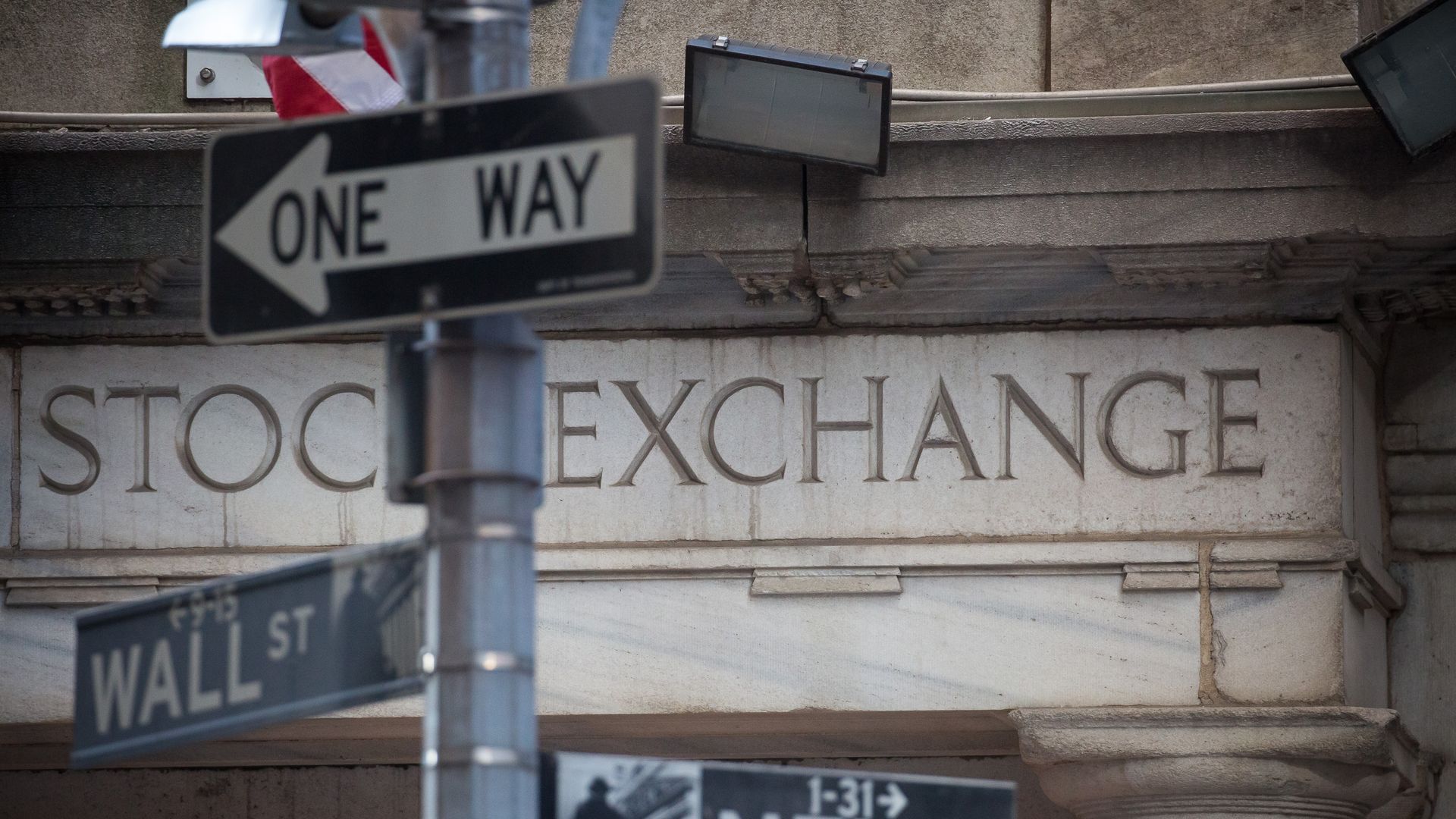 Image of the intersection of Wall St. and New St. with the New York Stock Exchange in the background