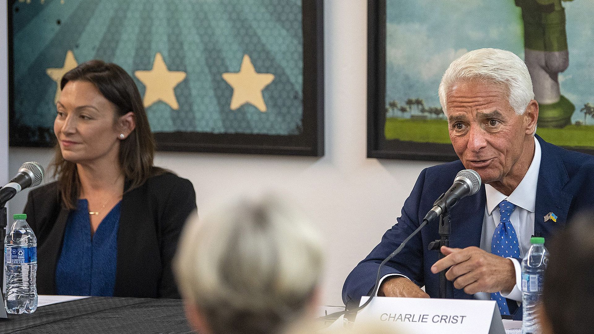 Florida Agriculture Commissioner Nikki Fried smiles as she sits behind a microphone.