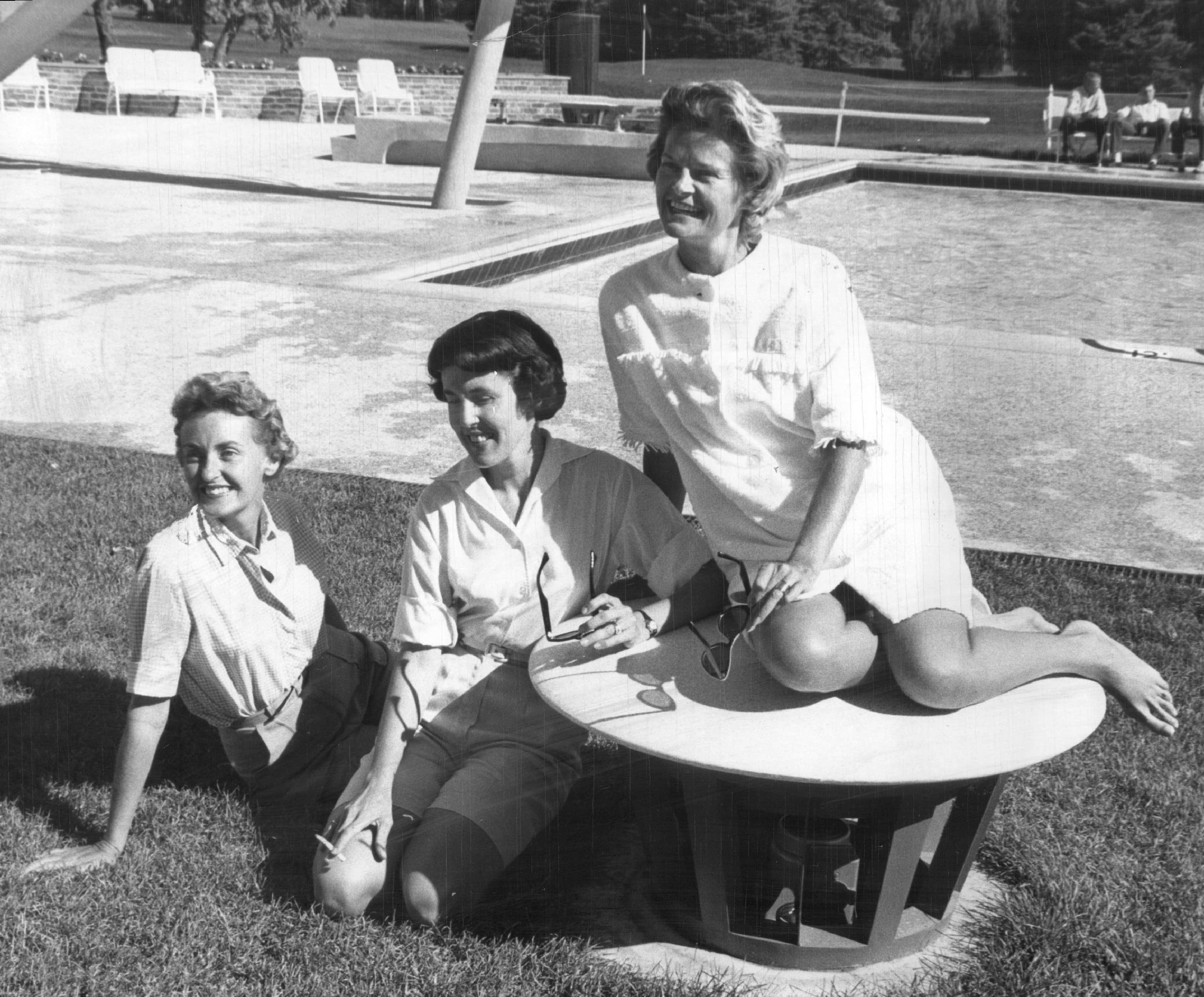 A black-and-white photo of women hanging out at the pool.