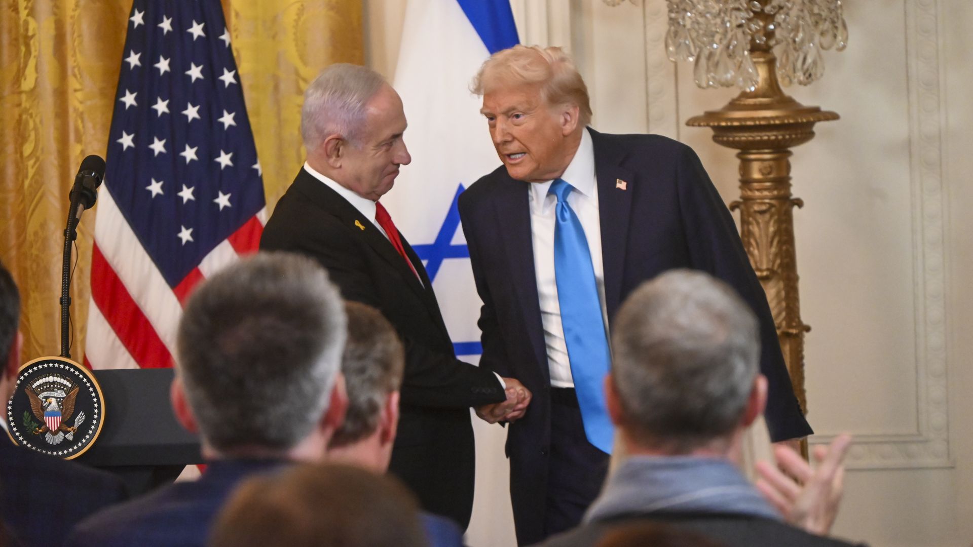 Donald Trump and Benjamin Netanyahu shake hands at the White House.