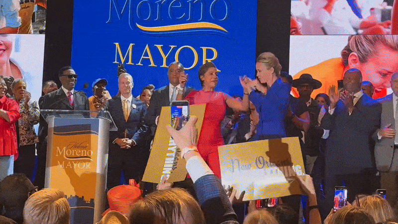 Helena Moreno dances onstage with Desi Charbonnet at Moreno's election party. Supporters wave signs that say "New Orleans, my everything."