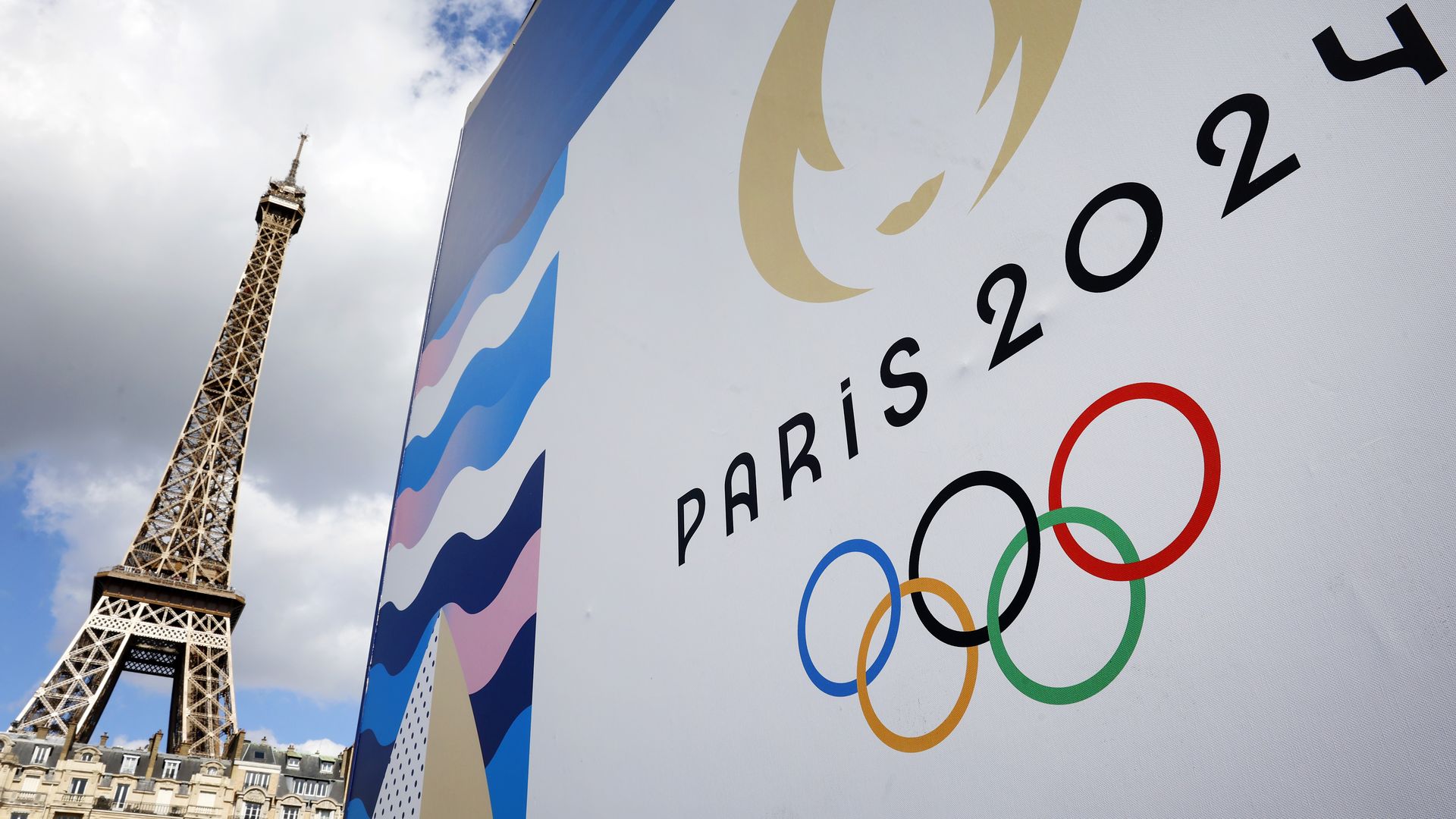 The Paris 2024 Olympic Games logo is displayed near the Eiffel Tower in Paris on April 21, 2024. 