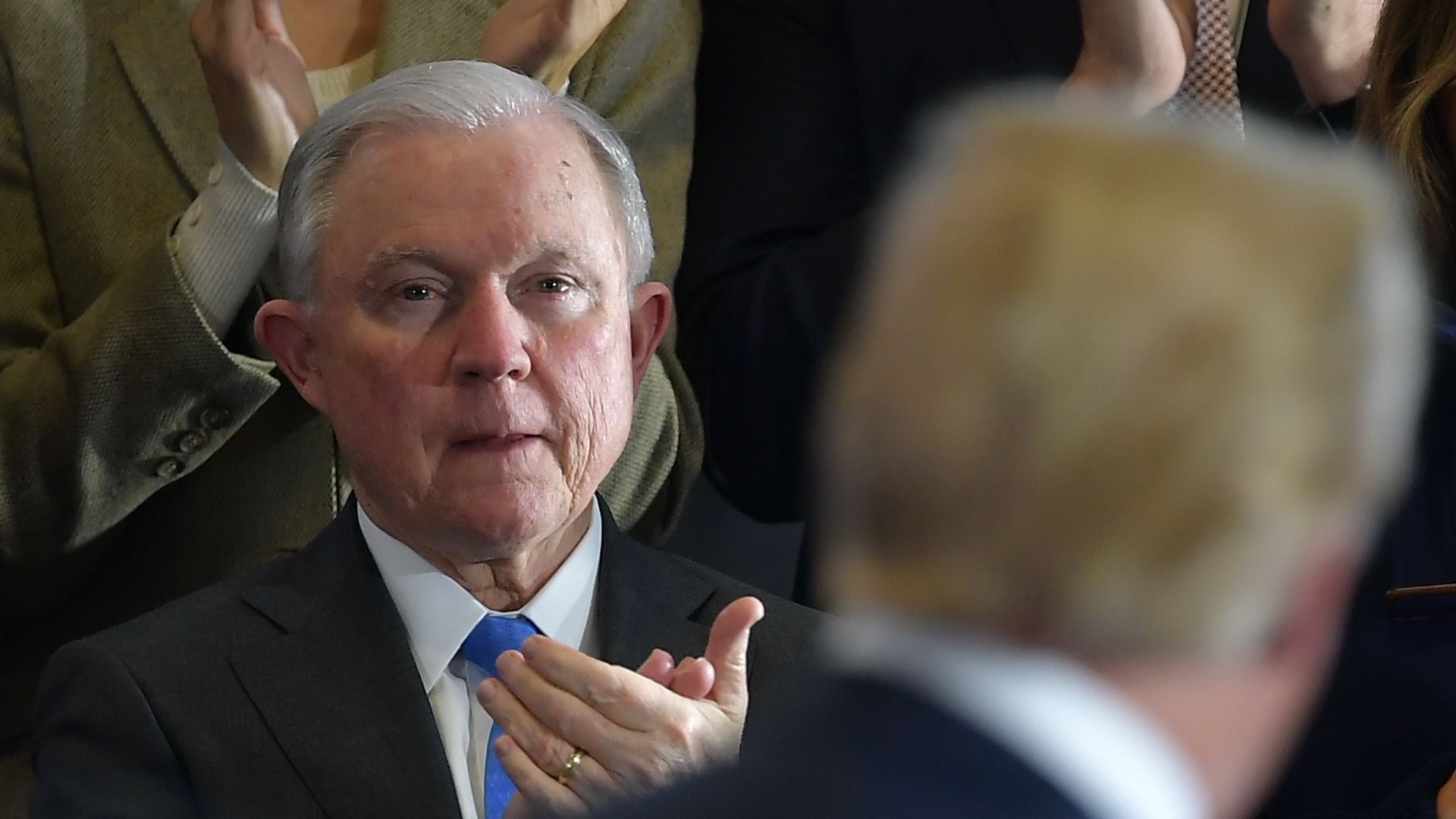 Attorney General Jeff Sessions applauds as President Trump speaks an event.
