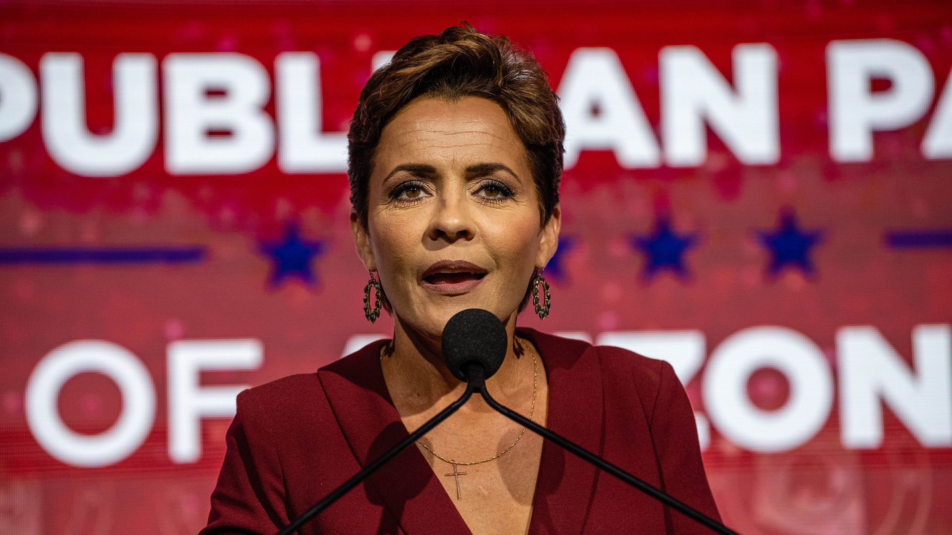 Photo of Kari Lake speaking into a mic at a campaign rally 