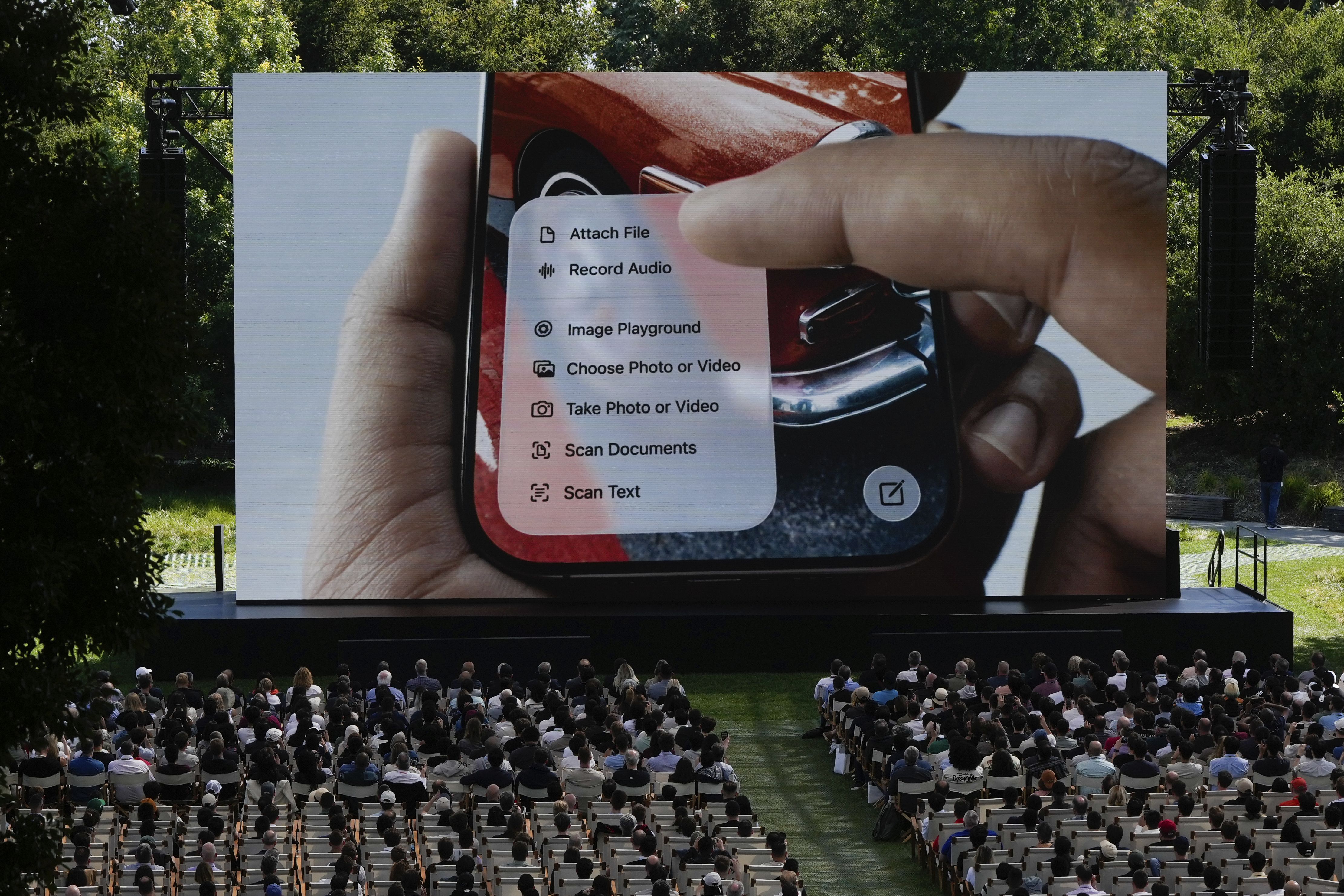 Attendees watch a presentation during an event on the Apple campus in Cupertino, Calif., Monday, June 9, 2025. 
