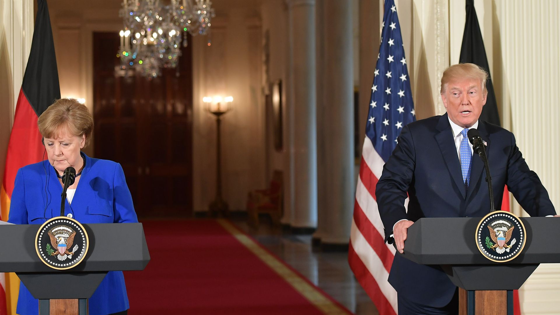 Merkel looks down at her podium while Trump speaks during a joint press conference