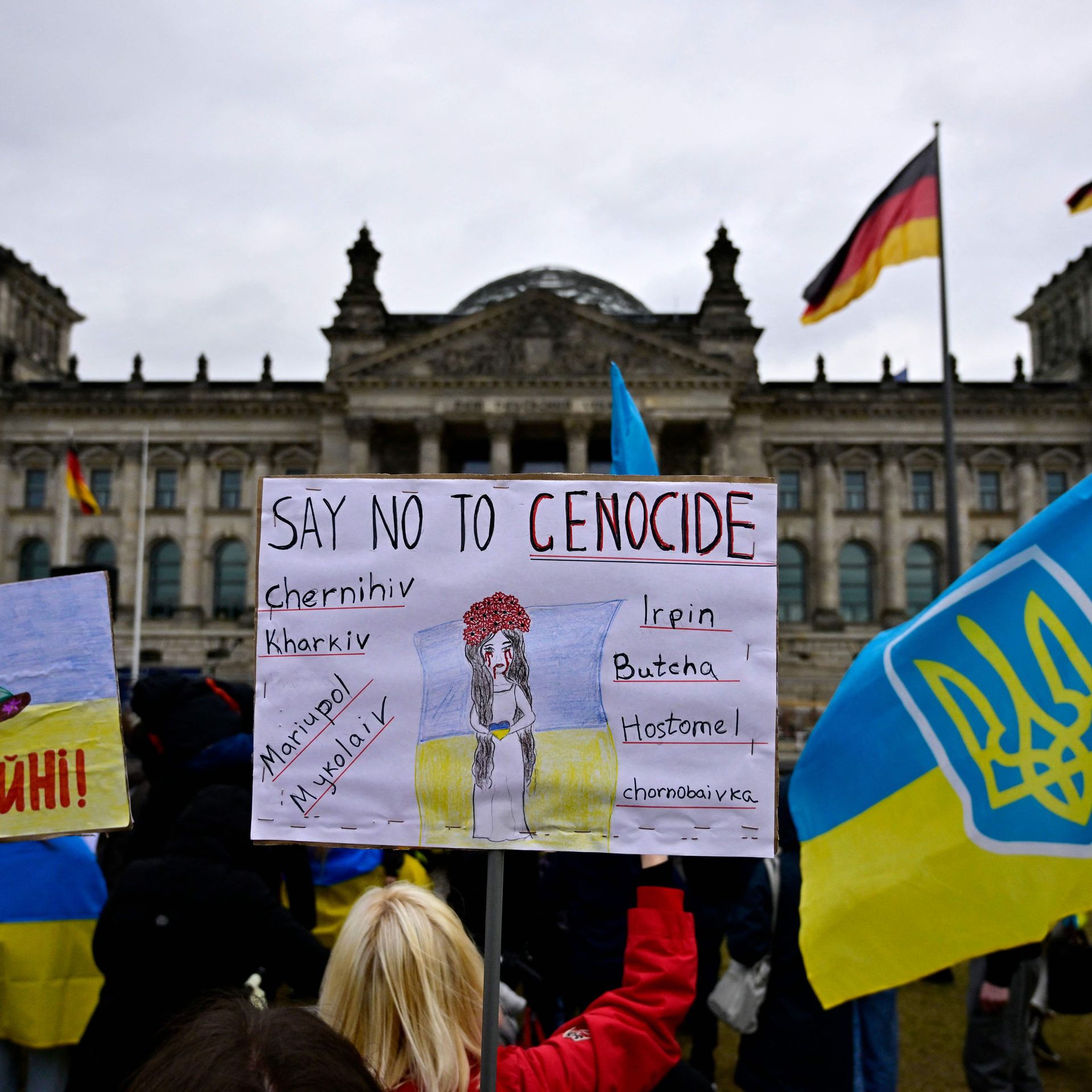 A participant displays a placard reading 'Say no to genocide' during a protest of pro-Ukrainian activists in front of the Reichstag building