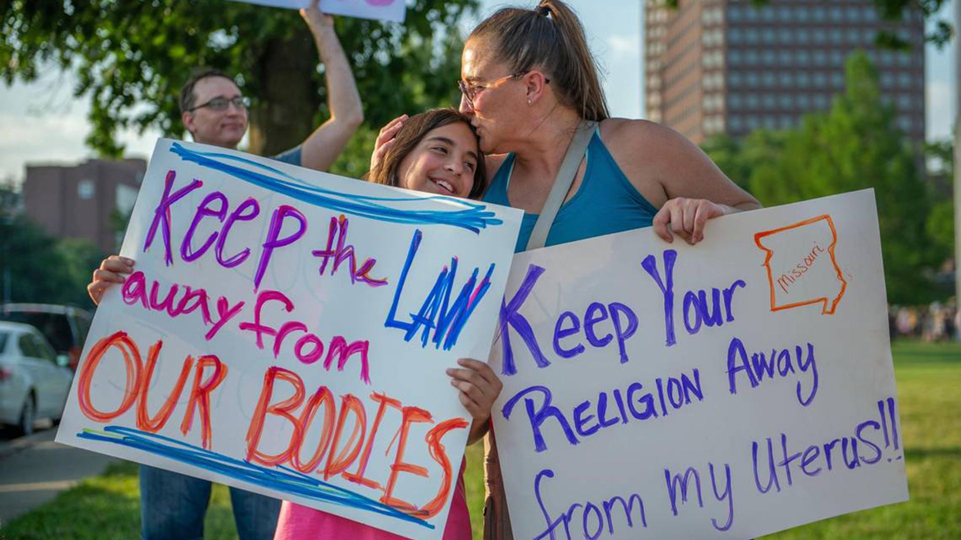 Eleven-year-old Giuliana Cangelosi, left, and her mother Nichole Cangelosi share a moment together while attending a protest opposing the Supreme Courtís ruling overturning federal protections for abortion rights June 24, 2022, in Mill Creek Park at Country Club Plaza. (Emily Curiel/Kansas City Star