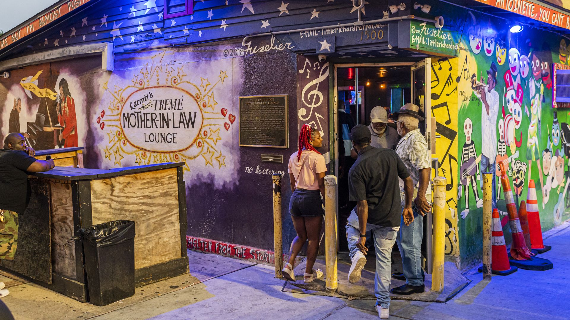 A small group of people walks into Kermit's Treme Mother-in-Law Lounge.