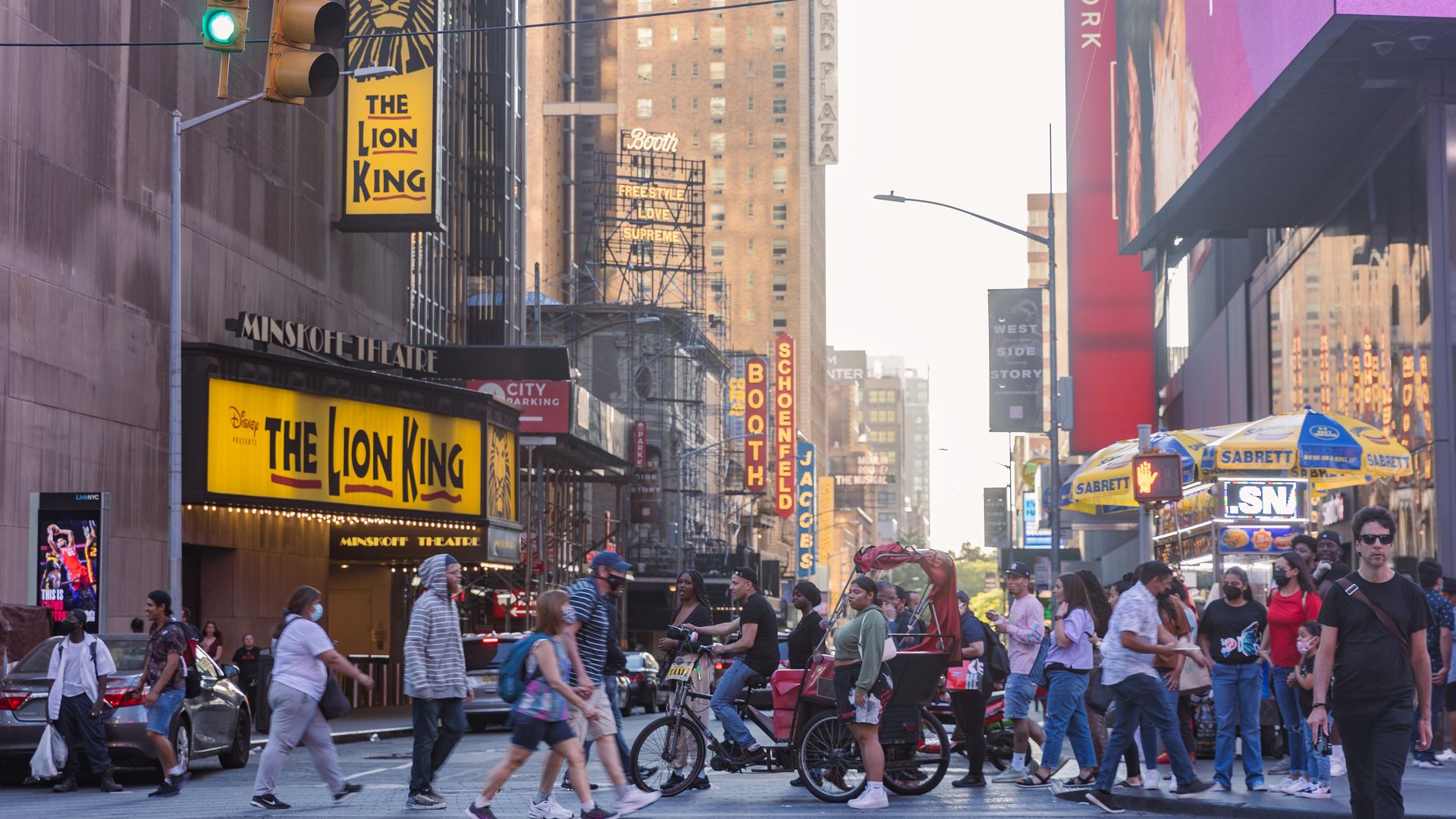 People walk past Broadway district in Manhattan, New York on June 24, 2021.