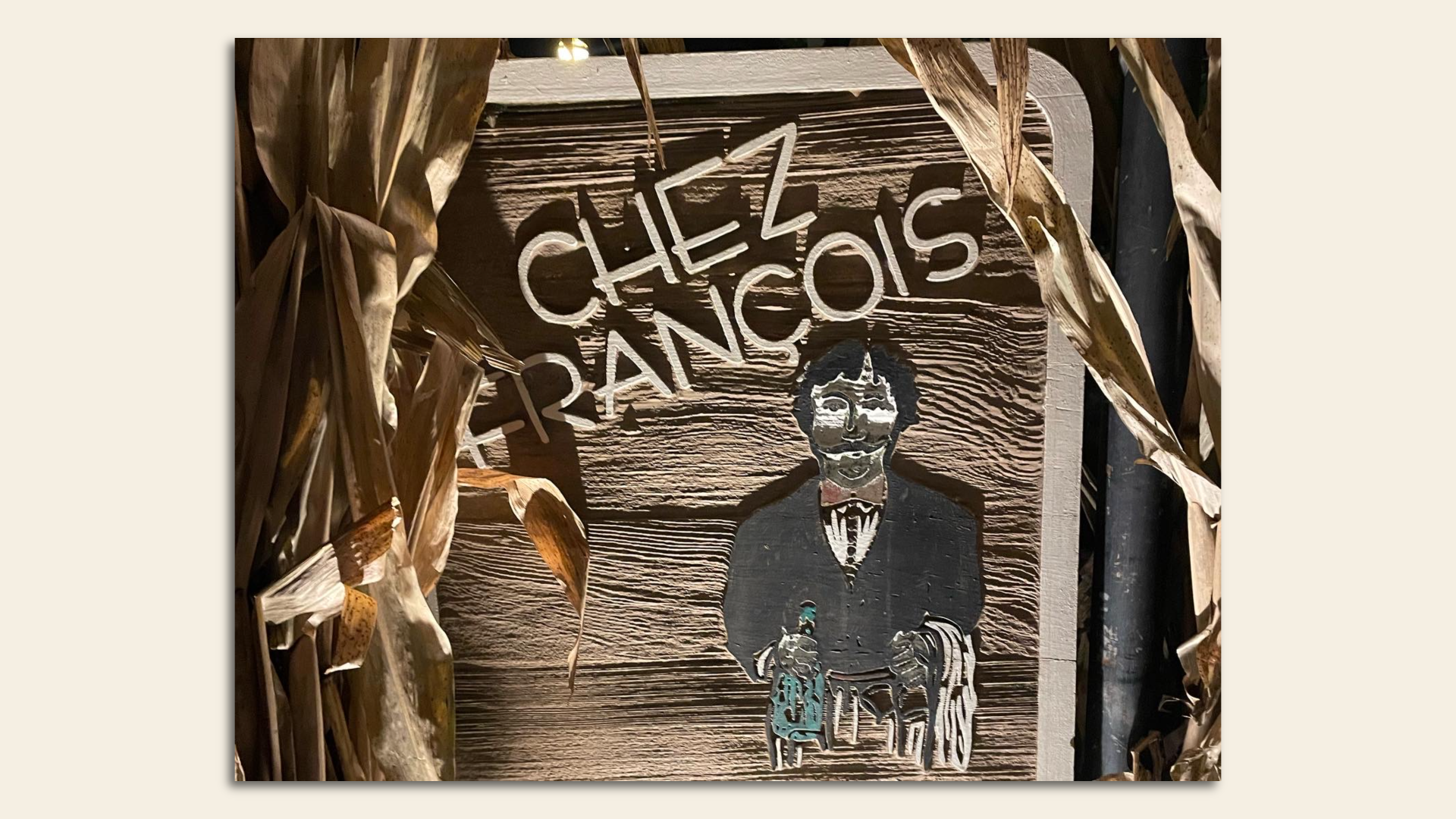 Wooden sign reading "Chez Francois" surrounded by corn stalks