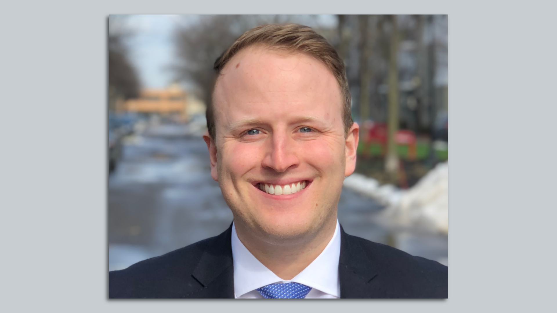 A headshot photo of Chris Berry in a suit and tie