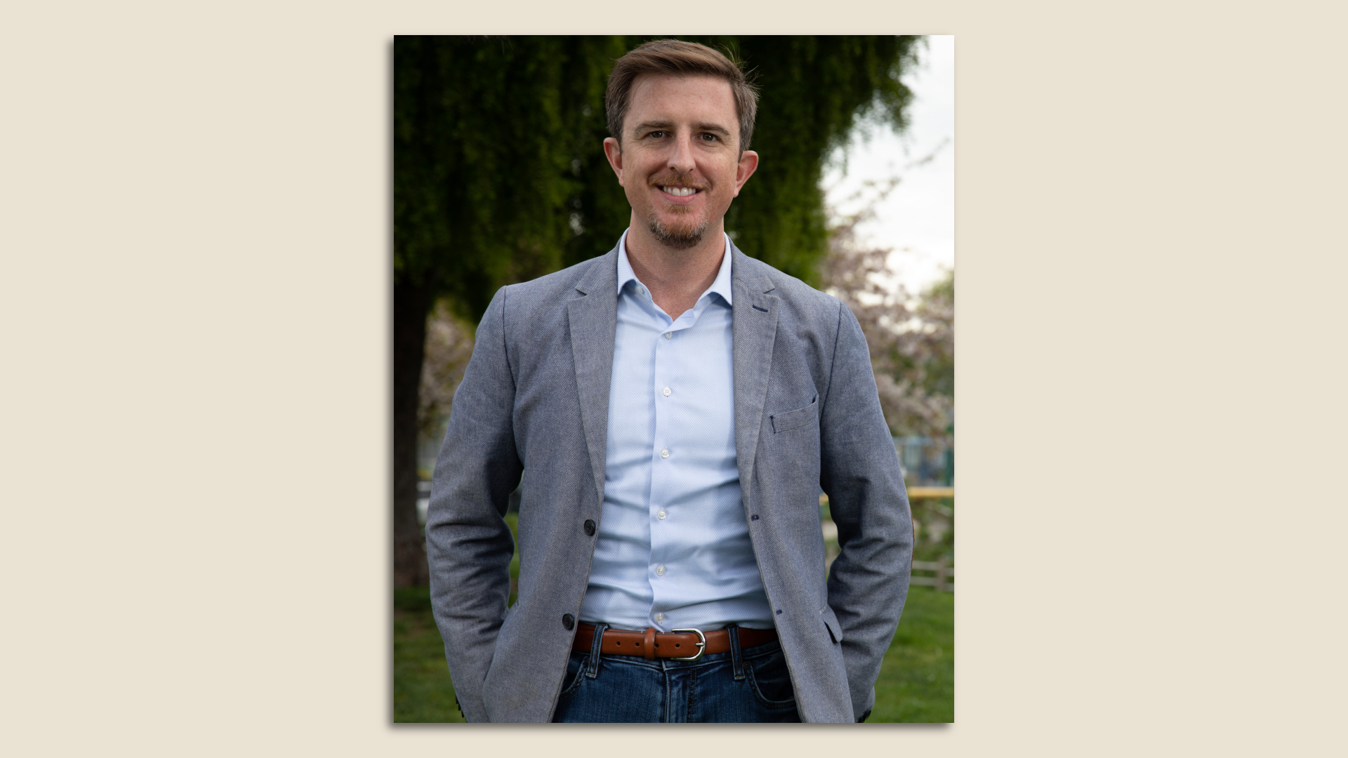 Photo of Trevor Chandler standing in a grassy area and smiling at the camera