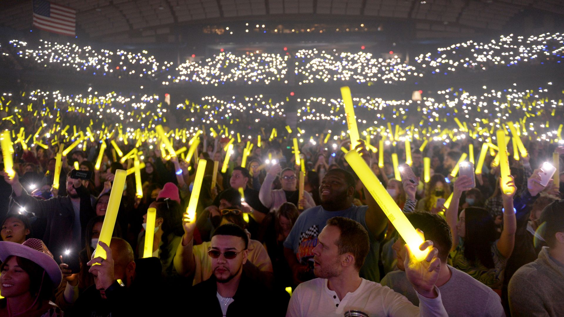 A large crowd holds up light sticks during iHeartRadio 103.5 KISS FM’s Jingle Ball 2021 in Chicago.