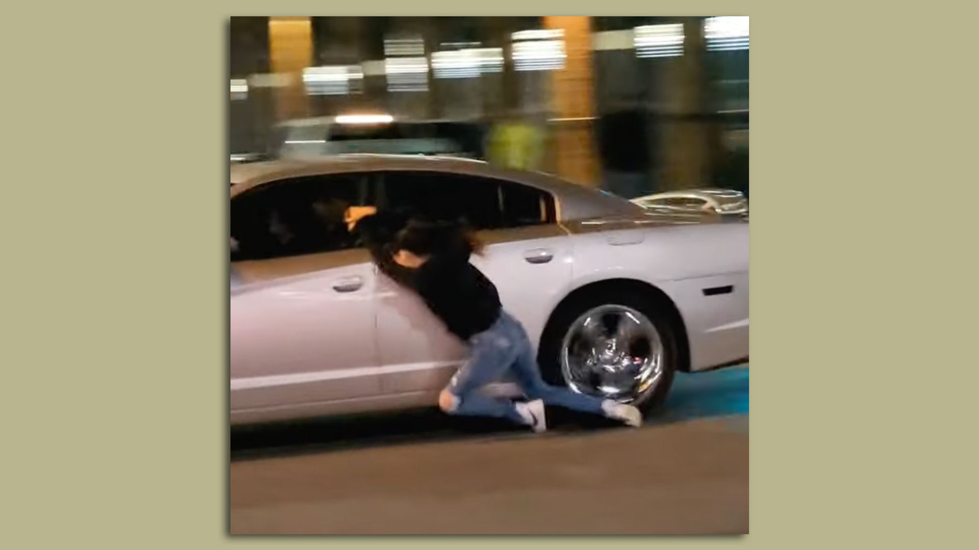 A screenshot of a girl hanging from a car.