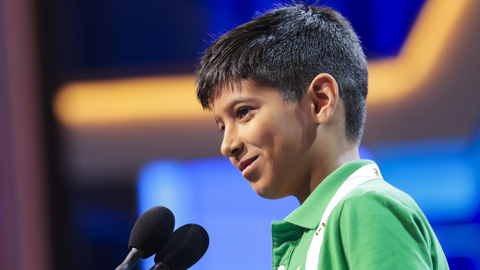 A photo of National Spelling Bee participant Aayu Chamoli standing at the mic