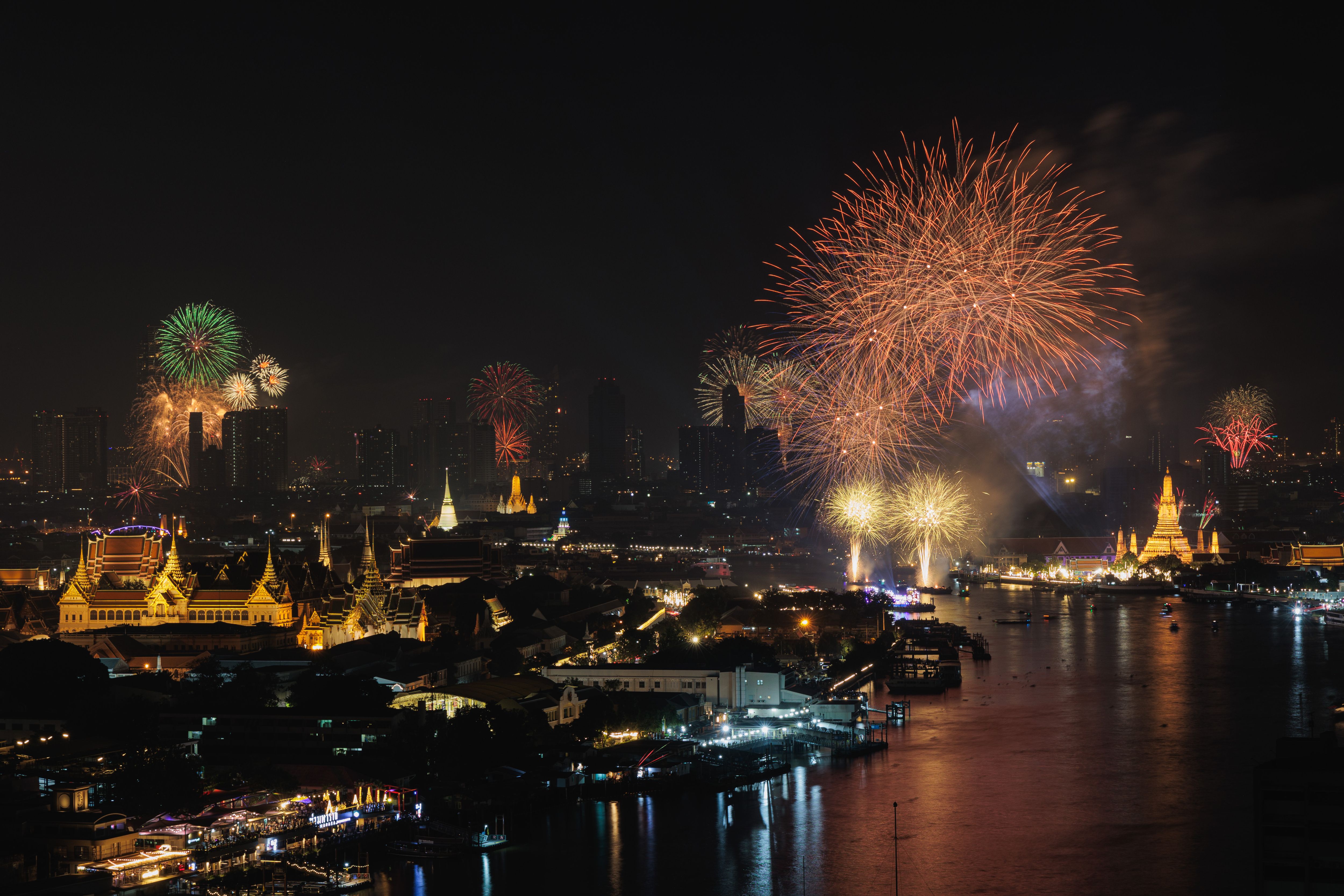 Fireworks seen above Chao Phraya river near The Grand Palace (L) during the new year celebration in Bangkok. 