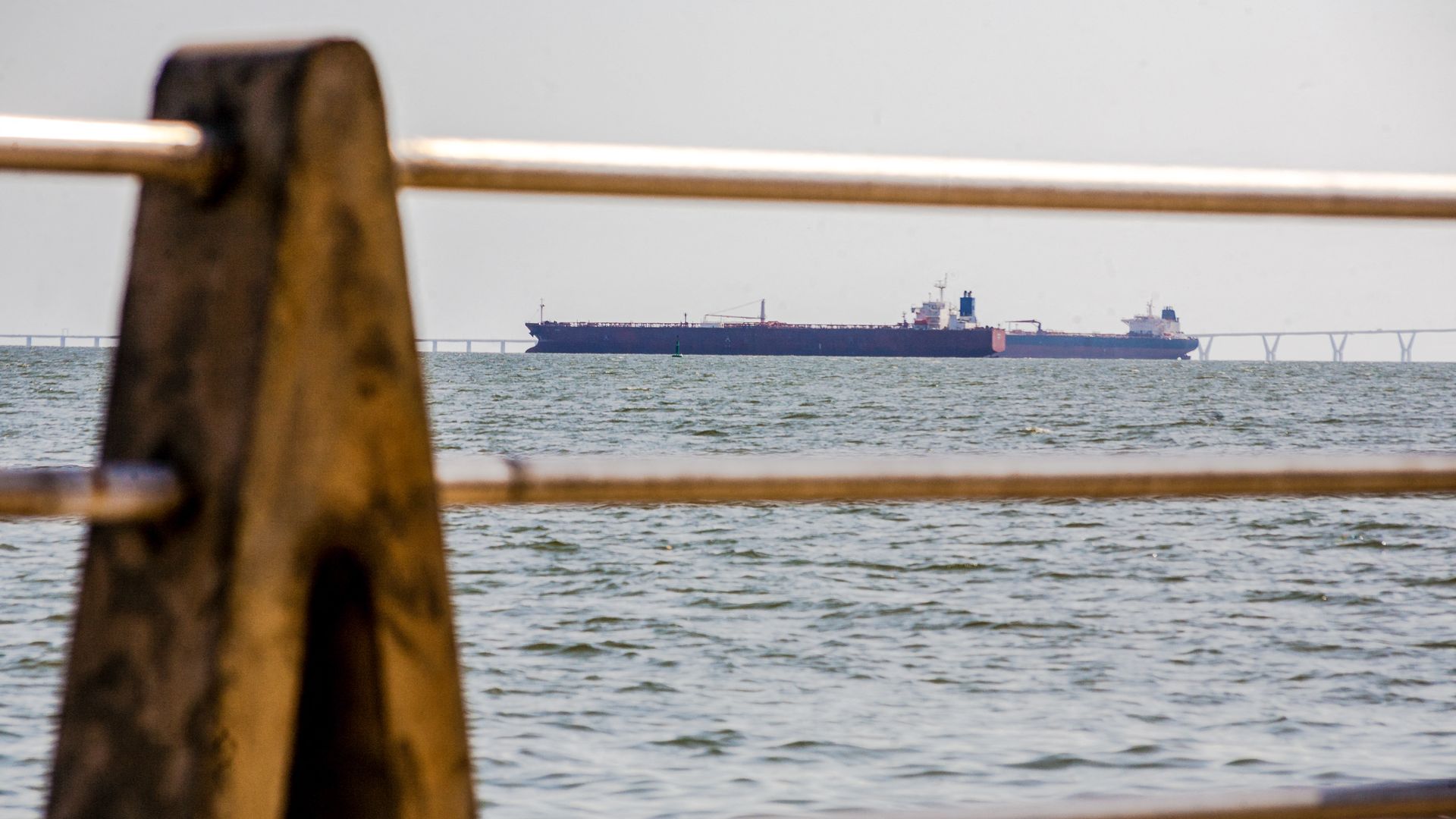 Two oil tankers can be seen in on Lake Maracaibo in Venezuela thorough a waterside barrier.