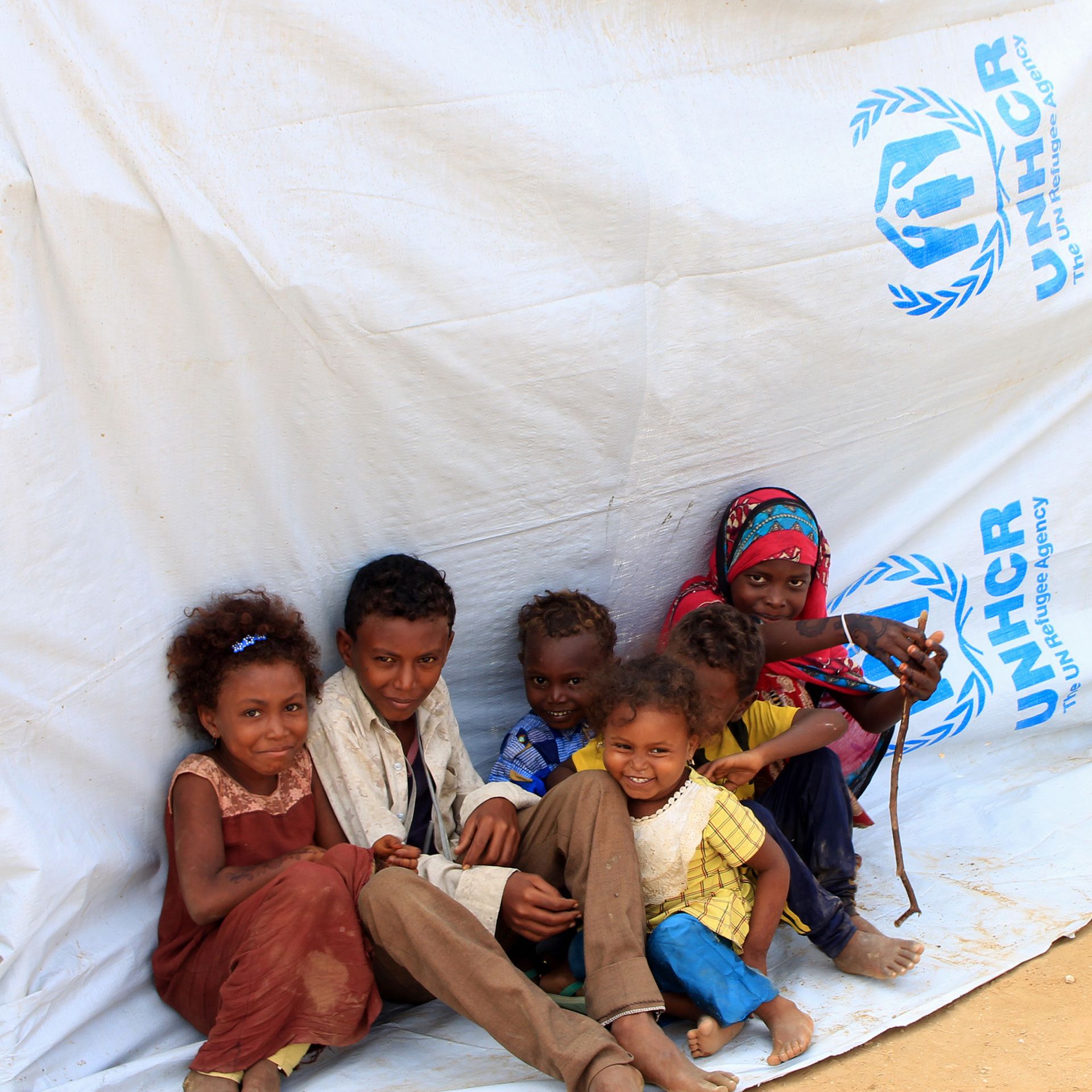 displaced Yemeni children sitting on a tarp