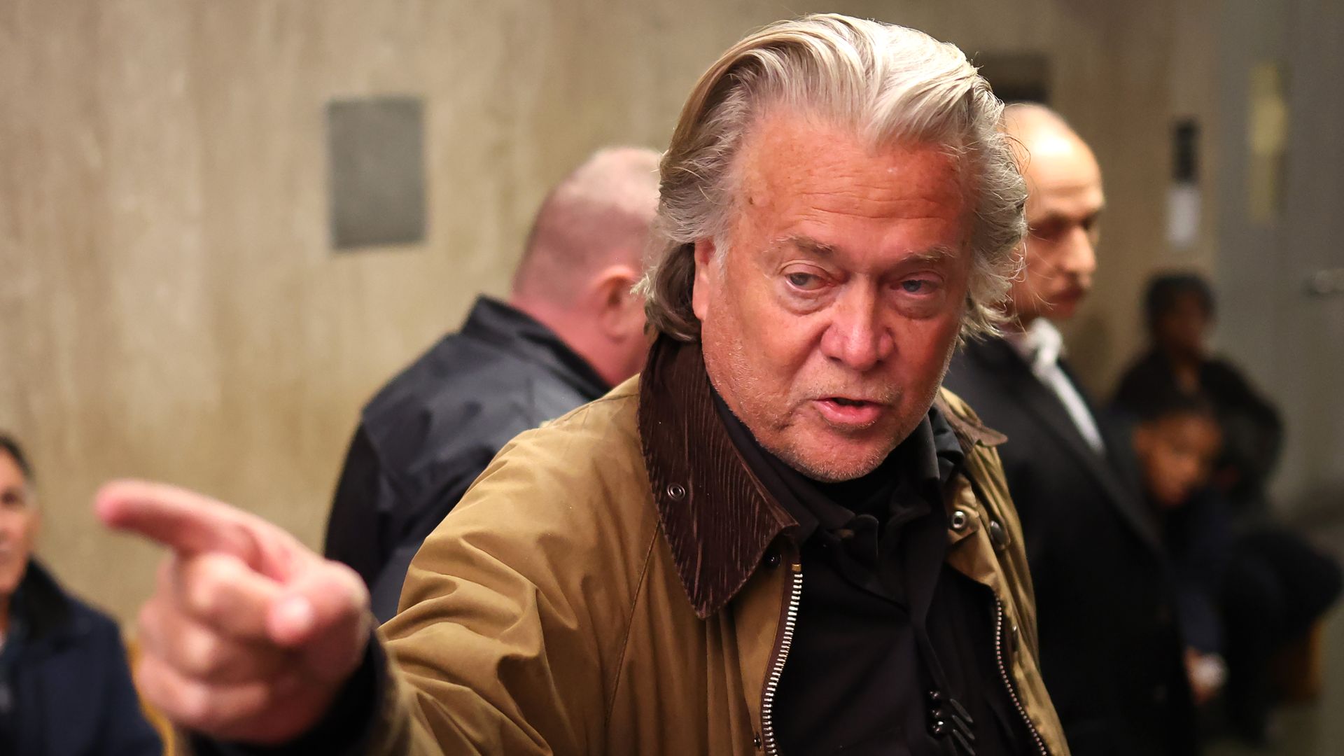 Steve Bannon points as he arrives for a court hearing at Manhattan Criminal Court.
