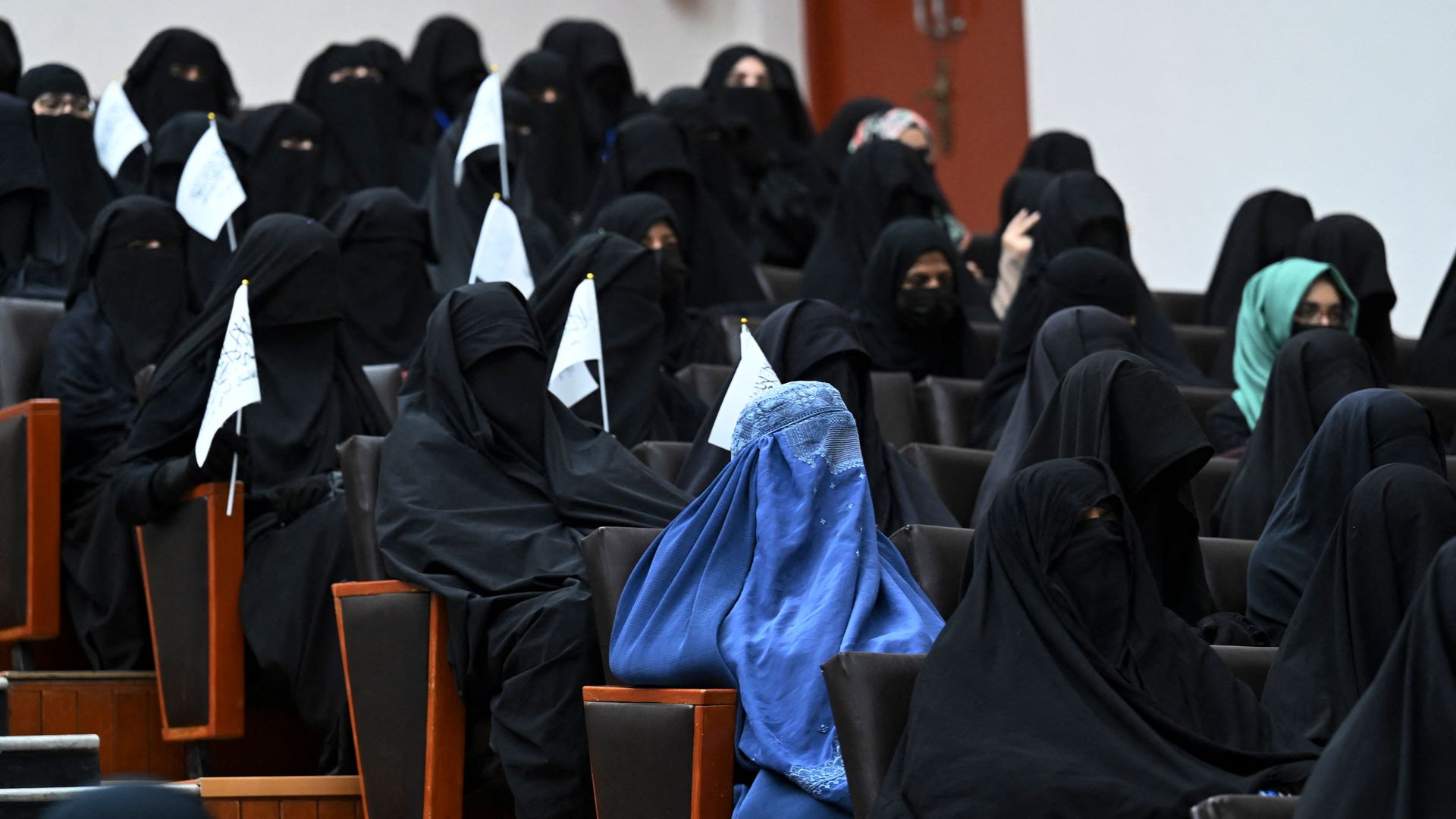 Veiled students hold Taliban flags as they listen a speaker before a pro-Taliban rally at the Shaheed Rabbani Education University in Kabul on September 11