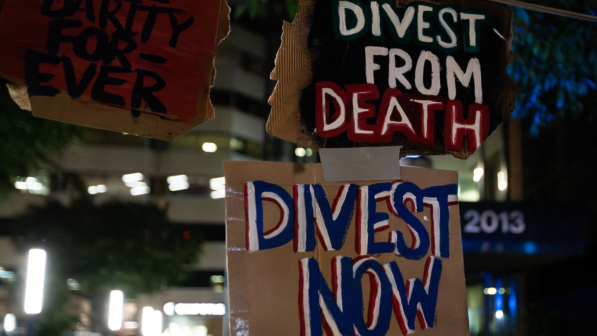 Signs reading "Divest from death" and "Divest now" hang at George Washington University's encampment of student protestors.